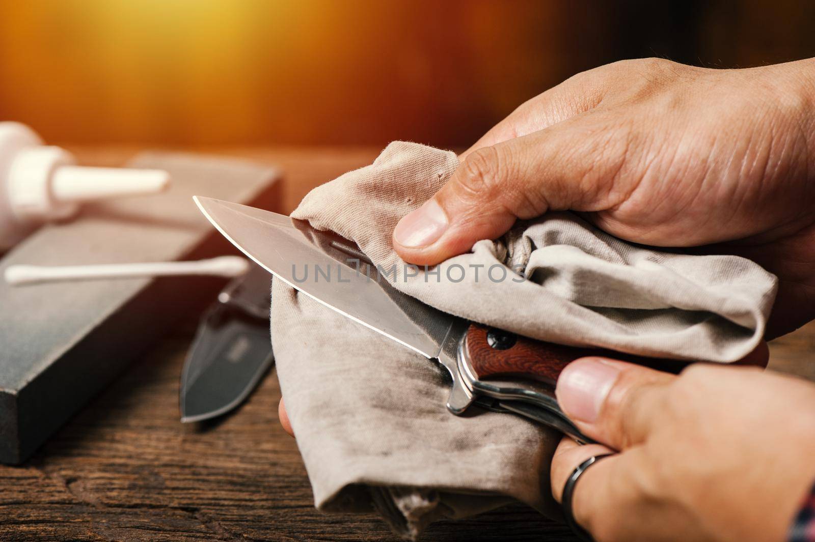 The man oiling his pocket knife. Pocket knife care and maintenance concept.