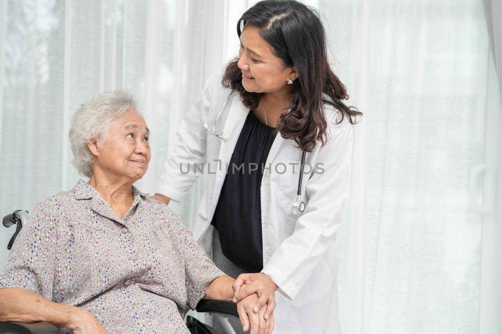Doctor help and care Asian senior or elderly old lady woman patient sitting on wheelchair at nursing hospital ward, healthy strong medical concept by pamai