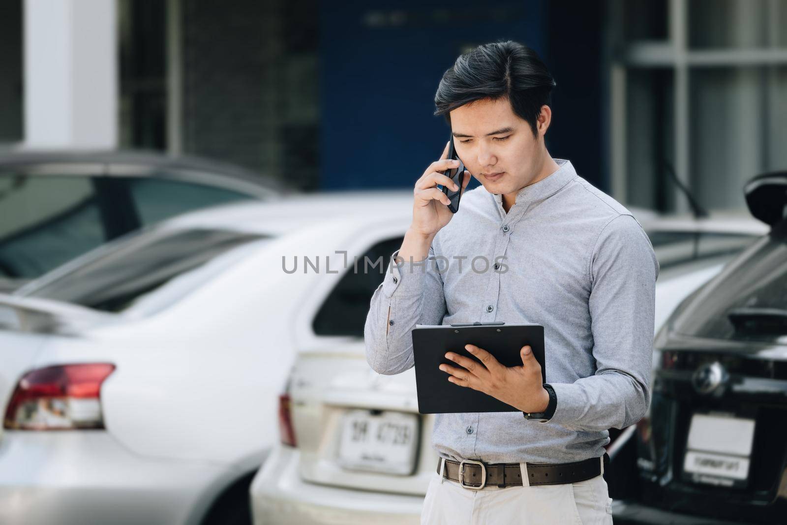 Insurance claim concept, car insurance policy owner talking on the phone with car insurance company holding insurance documents to inform car repair