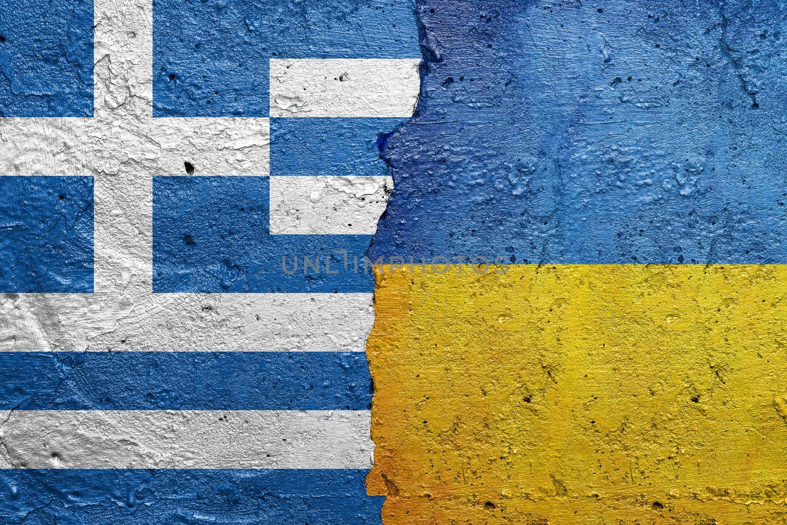 Greece and Ukraine - Cracked concrete wall painted with a Greek flag on the left and a Ukrainian flag on the right stock photo by adamr