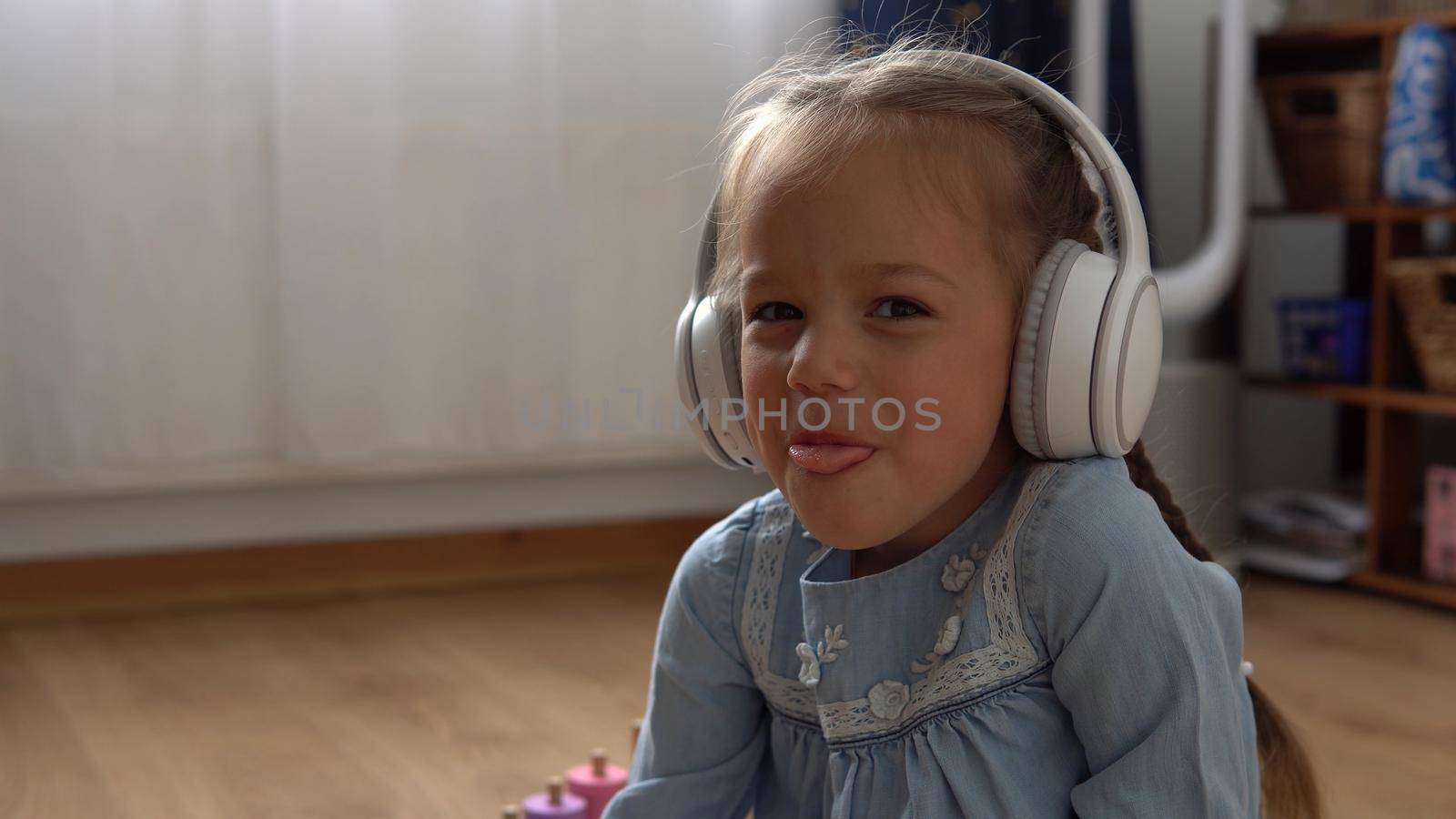 Close up handsome smiling Girl listening music headphones indoor. Children and technology. Love of music, children's dreams hobbies. Talented happy little child leasure. Childhood, musicality, hobby.