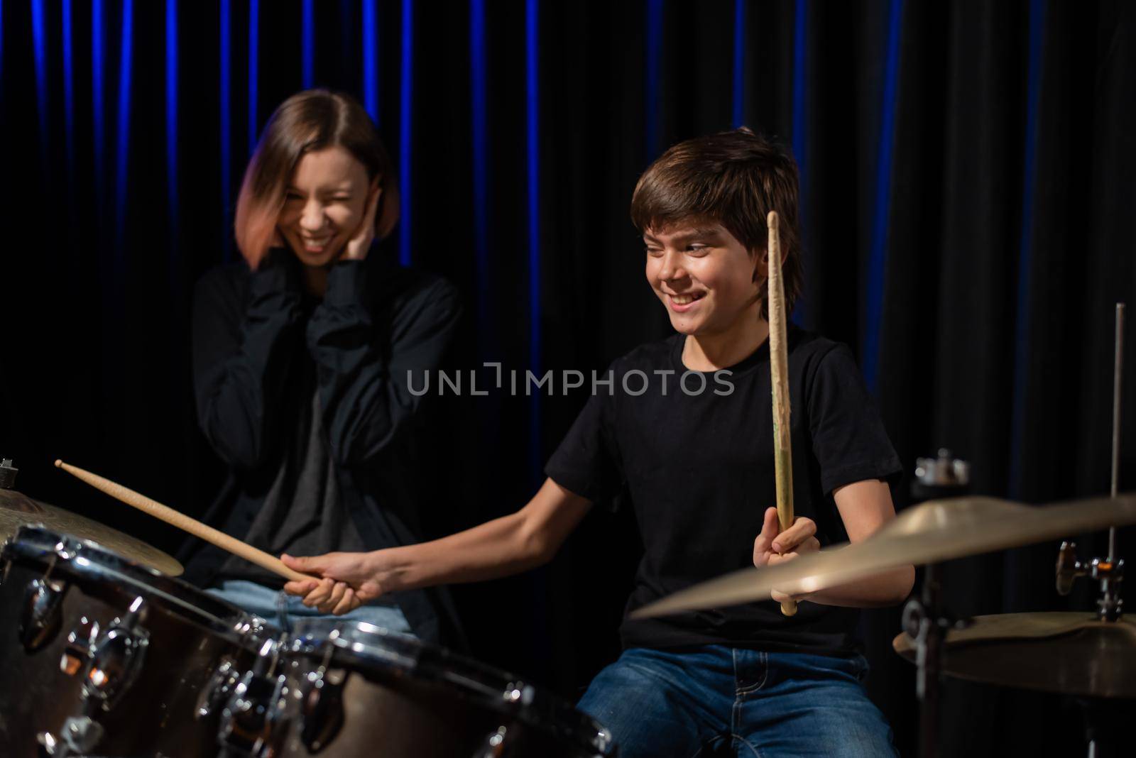 Young woman teaching boy to play drums. by mrwed54