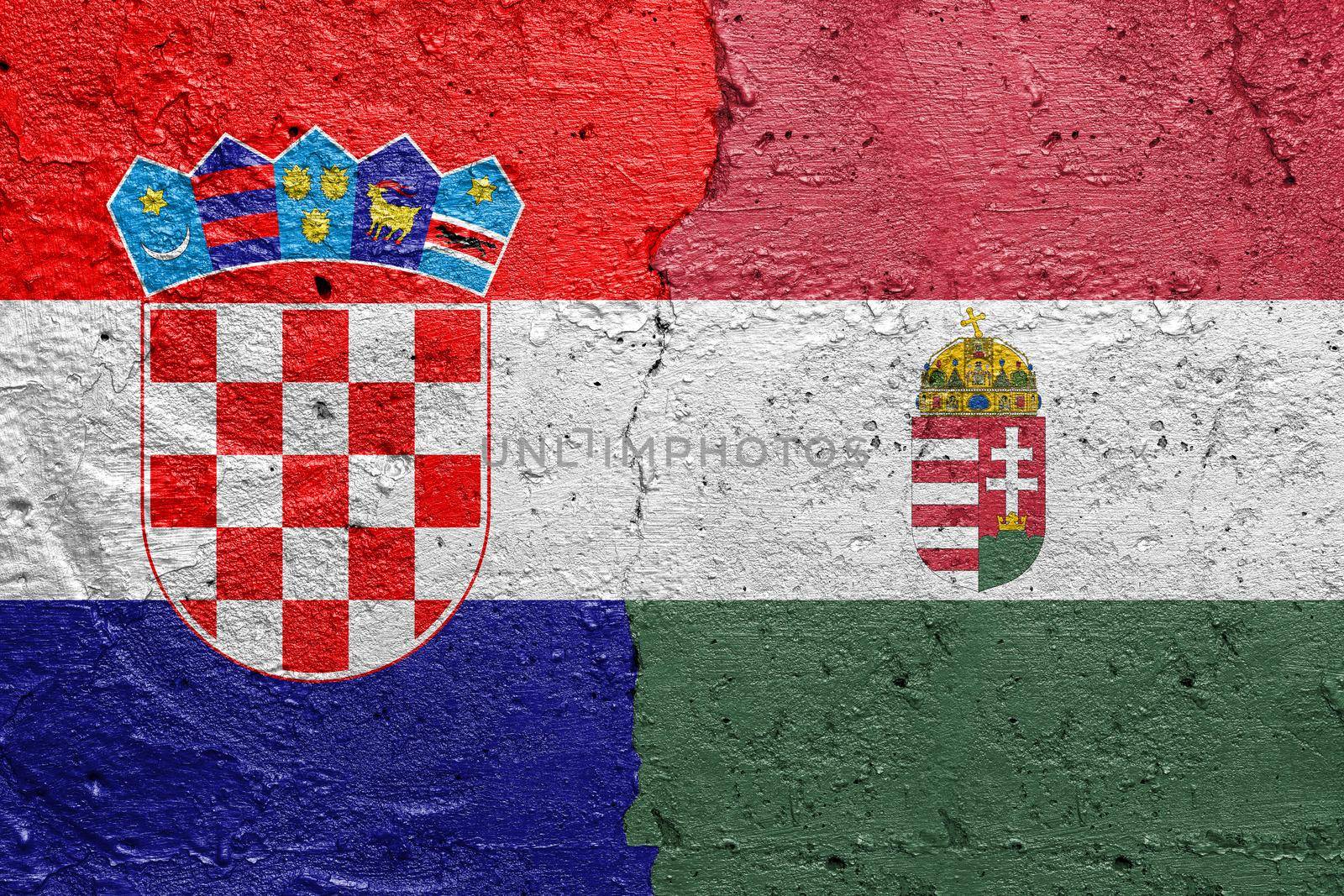 Croatia and Hungary - Cracked concrete wall painted with a Croatian flag on the left and a Hungarian flag on the right stock photo by adamr