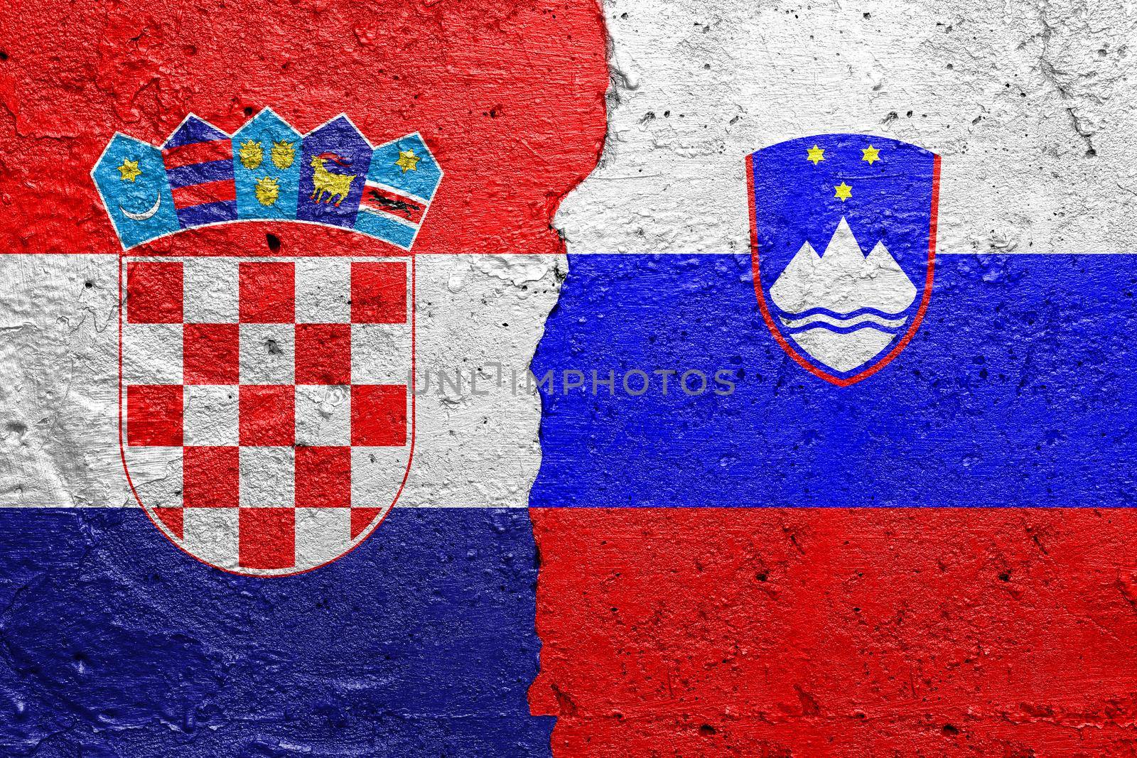 Croatia and Slovenia - Cracked concrete wall painted with a Croatian flag on the left and a Slovenian flag on the right stock photo by adamr