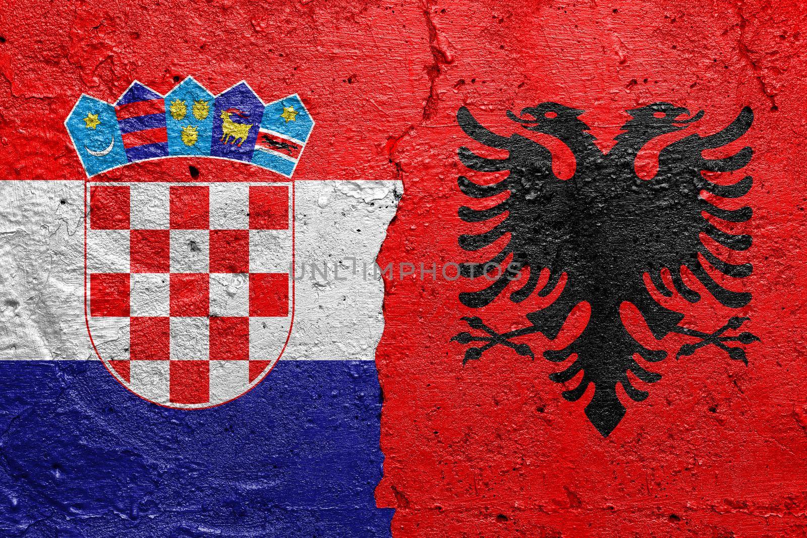 Croatia and Albania - Cracked concrete wall painted with a Croatian flag on the left and a Albanian flag on the right