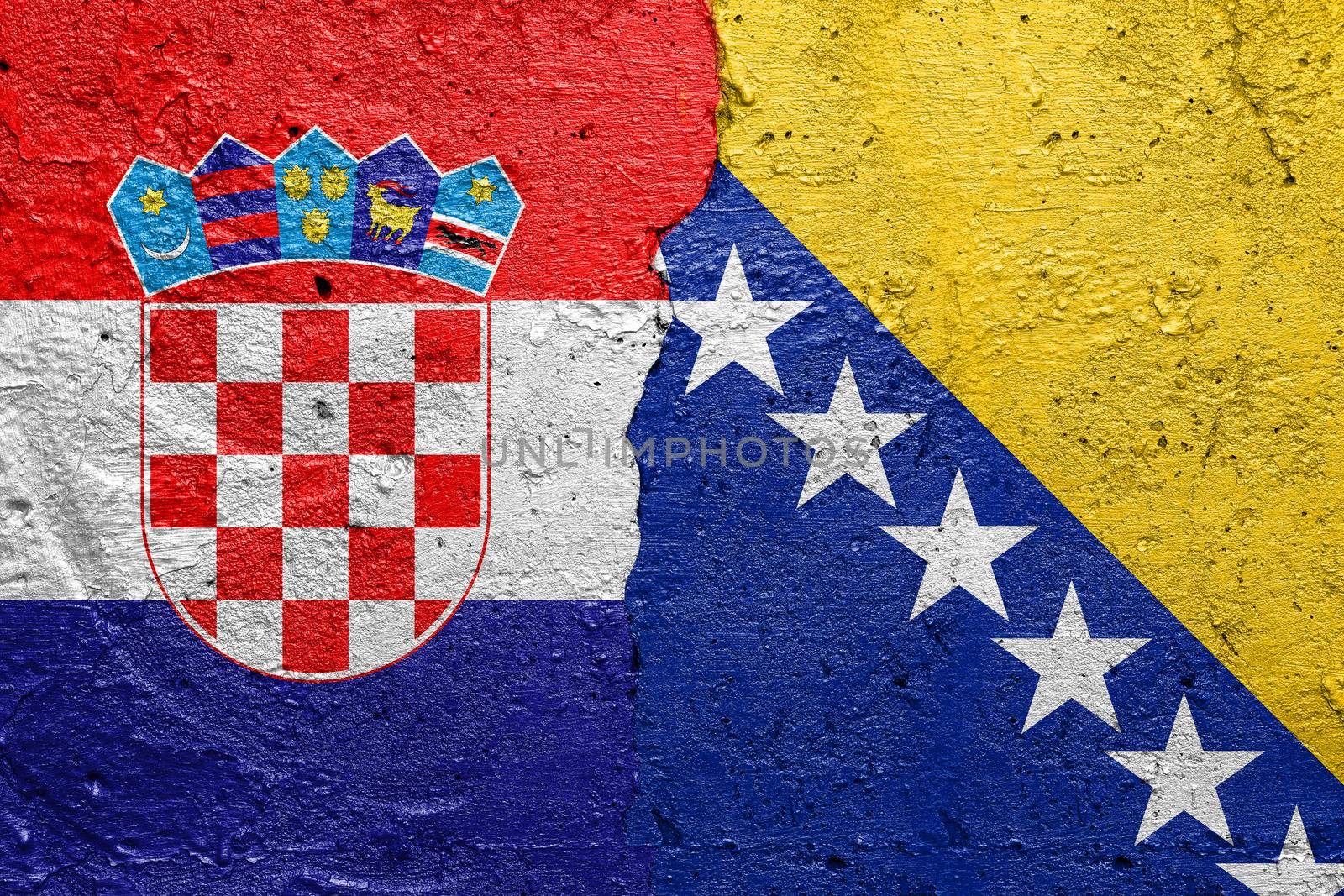 Croatia and Bosnia and Herzegovina - Cracked concrete wall painted with a Croatian flag on the left and a Bosnia flag on the right stock photo by adamr