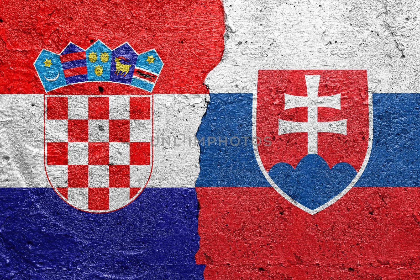 Croatia and Slovakia - Cracked concrete wall painted with a Croatian flag on the left and a Slovakian flag on the right stock photo by adamr