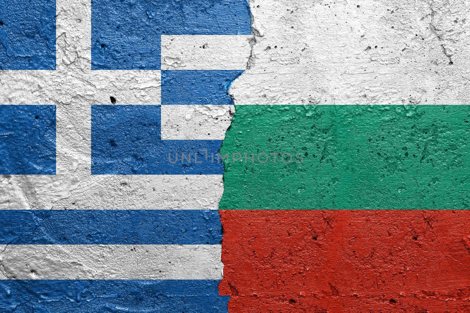 Greece and Bulgaria - Cracked concrete wall painted with a Greek flag on the left and a Bulgarian flag on the right stock photo by adamr