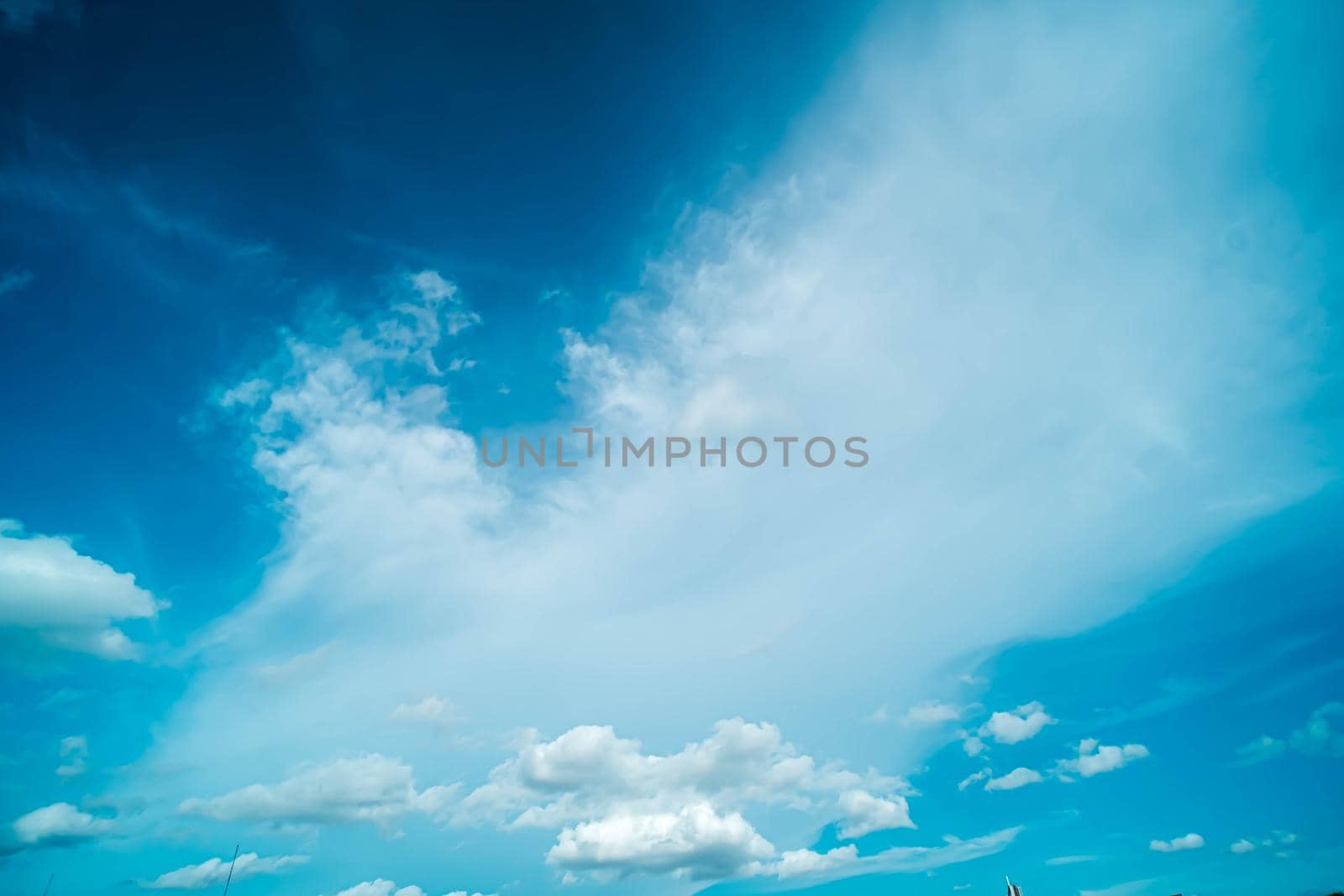 White fluffy clouds against blue sky in summer nature season weather background by Petrichor