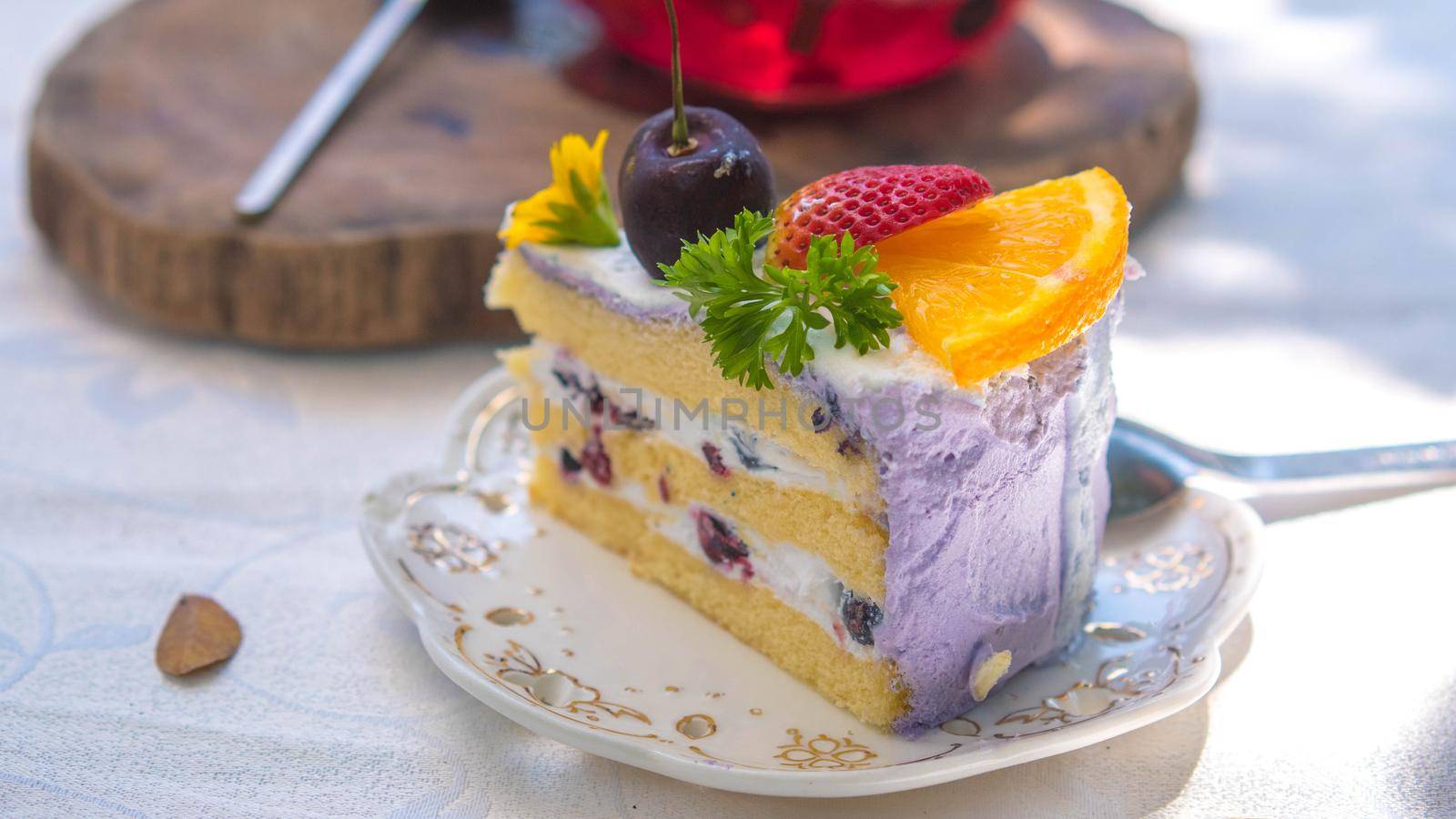 Close up Slice birthday fruit cake in plate violet delicious cream in layer
