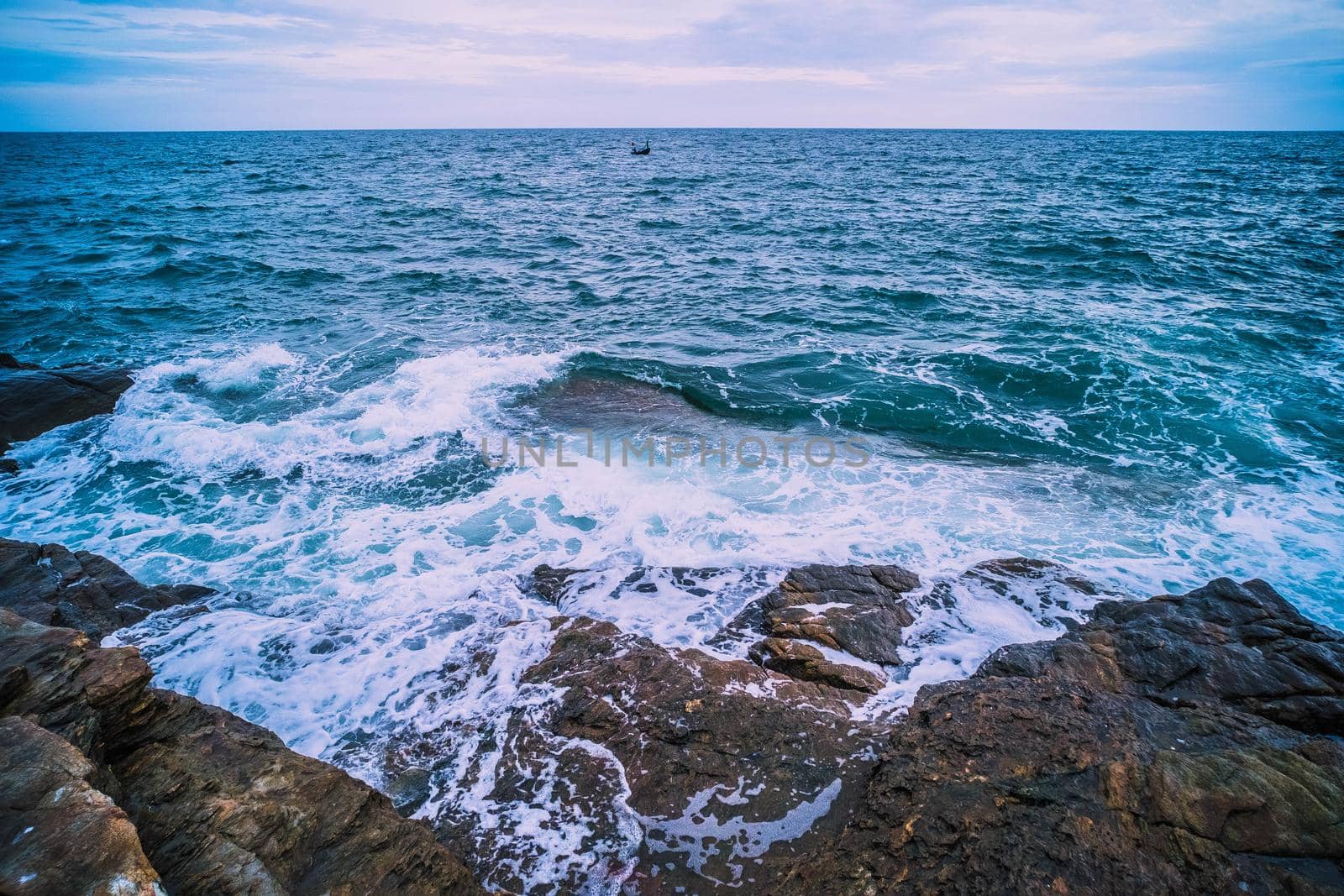 Sea Ocean with Smooth Wave and Rock landscape with blue sky. Nature of Seascape vacation time.
