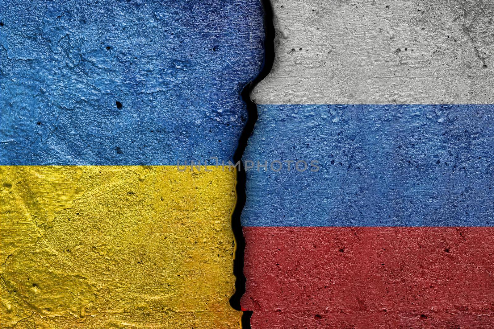 Ukraine and Russia - Cracked concrete wall painted with a Ukrainian flag on the left and a Russian flag on the right