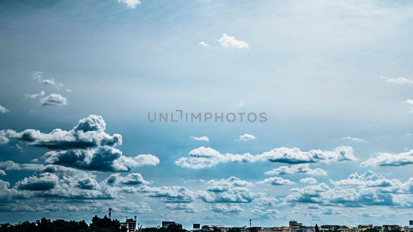 Panoramic view of city background blue sky with white huge single floating clouds against blue sky