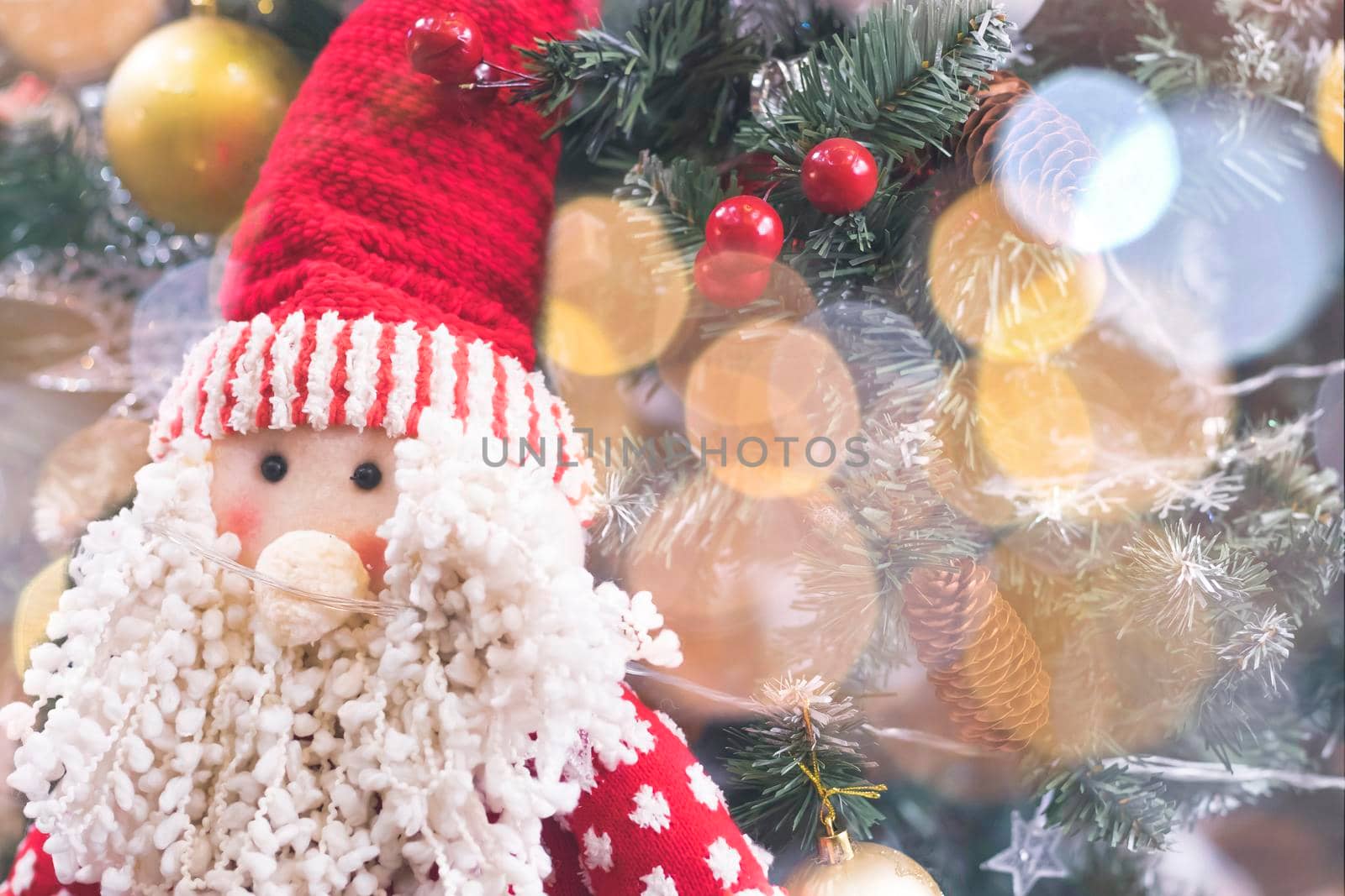 Happy santa claus decoration on the table with christmas tree bokeh on background by Petrichor