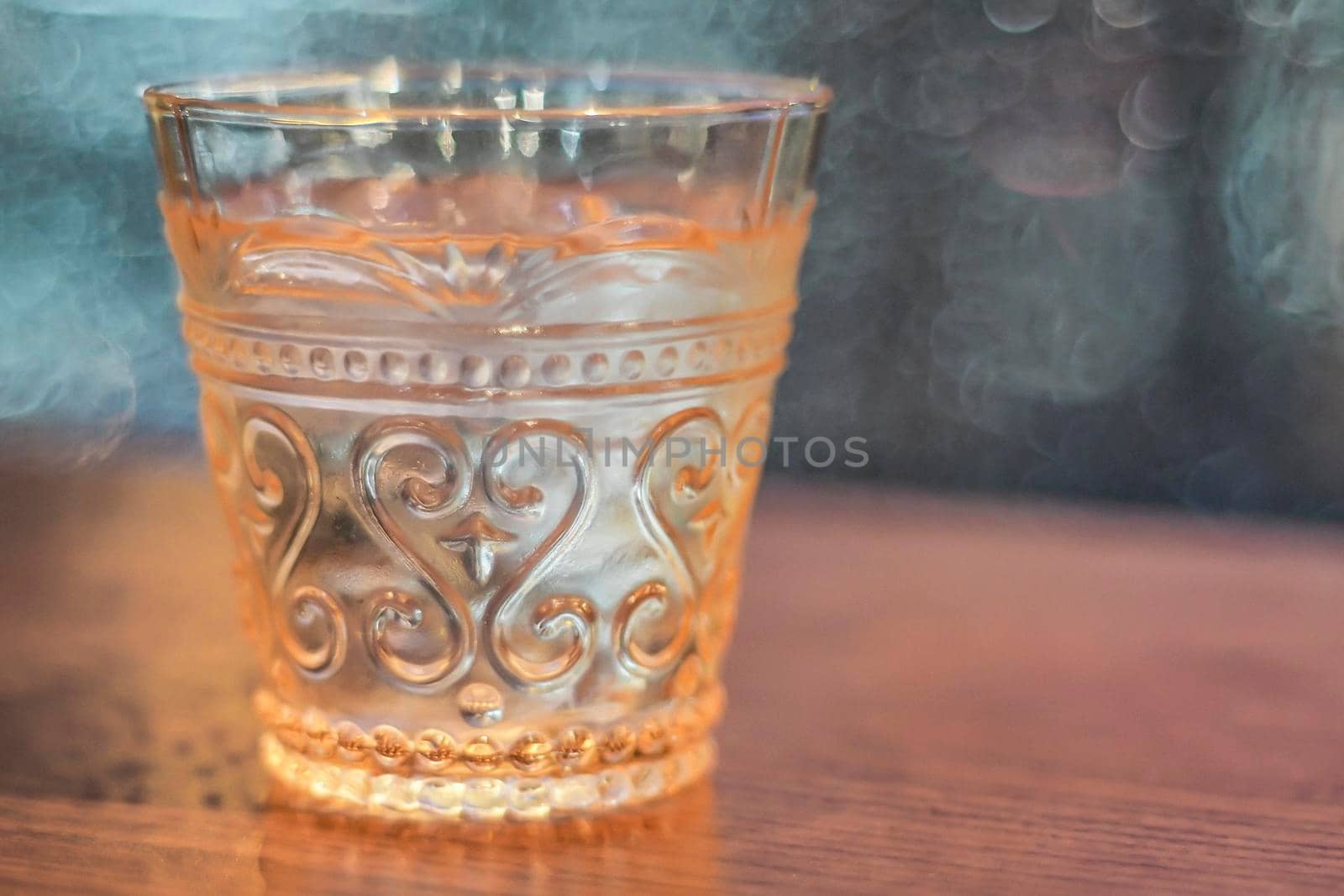 Drinking water in beautiful vintage whisky amber color glasses object on blur background.