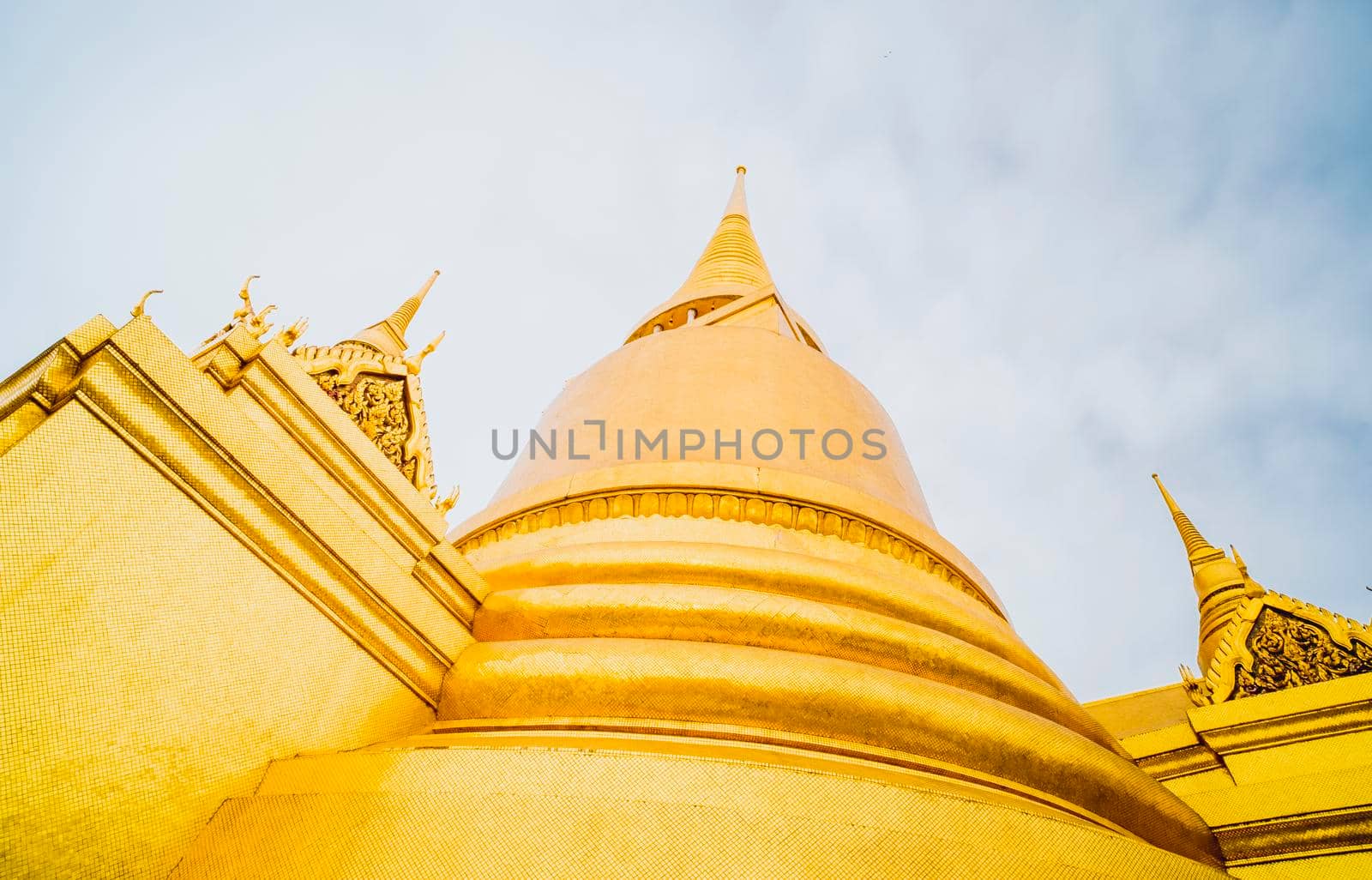 Golden Stupa of Temple of the Emerald Buddha.  Wat Phra Si Rattana Satsadaram.  Wat Phra Kaew. landmark of Bangkok Thailand with pink sky at dusk