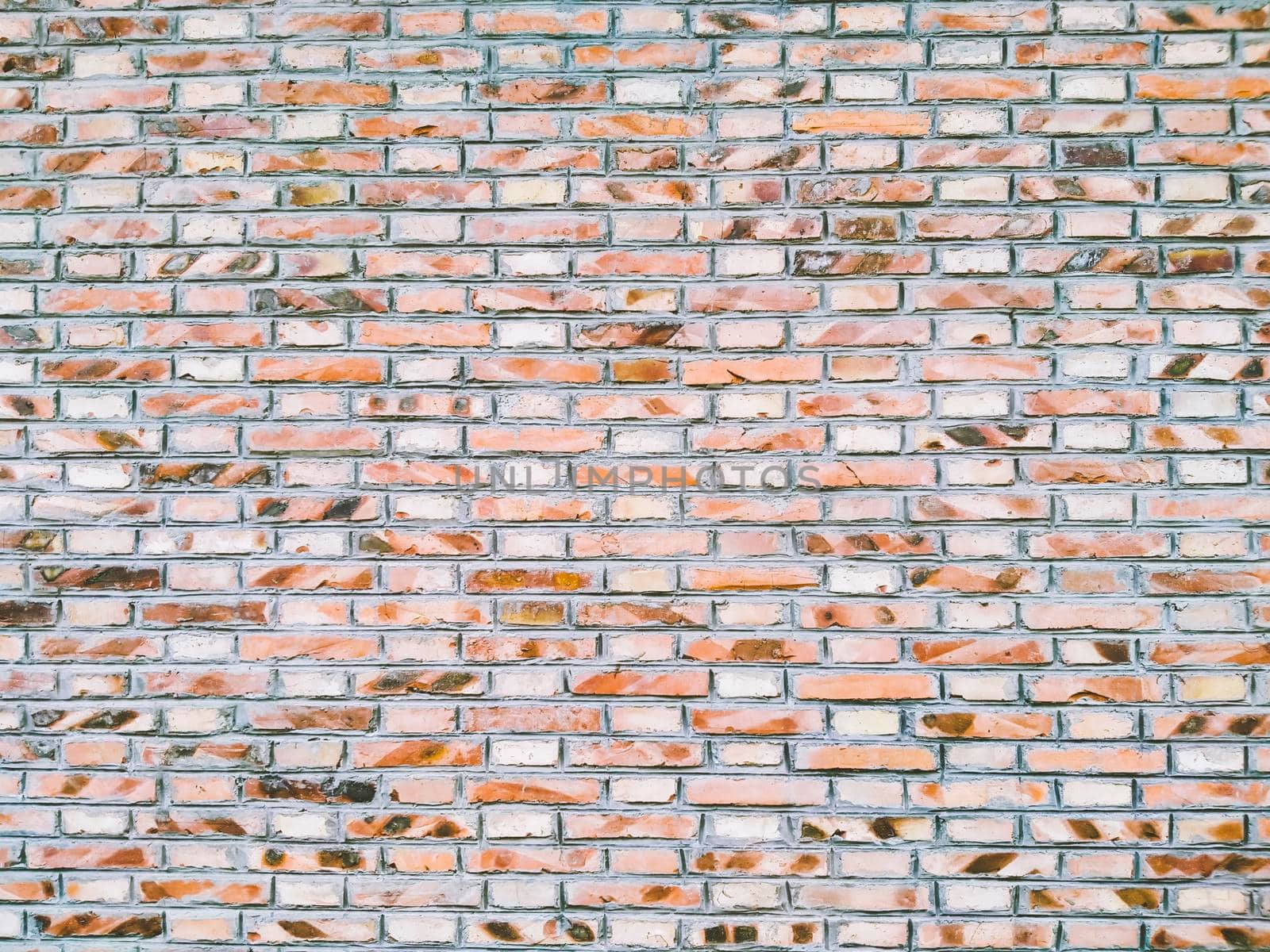 Orange Random Brick Glass & Resin Mesh Mounted Mosaic Tiles creates a beautiful multi-dimensional effect. Old-fashioned brick building. Background of random orange green tone brick wall, pattern, close