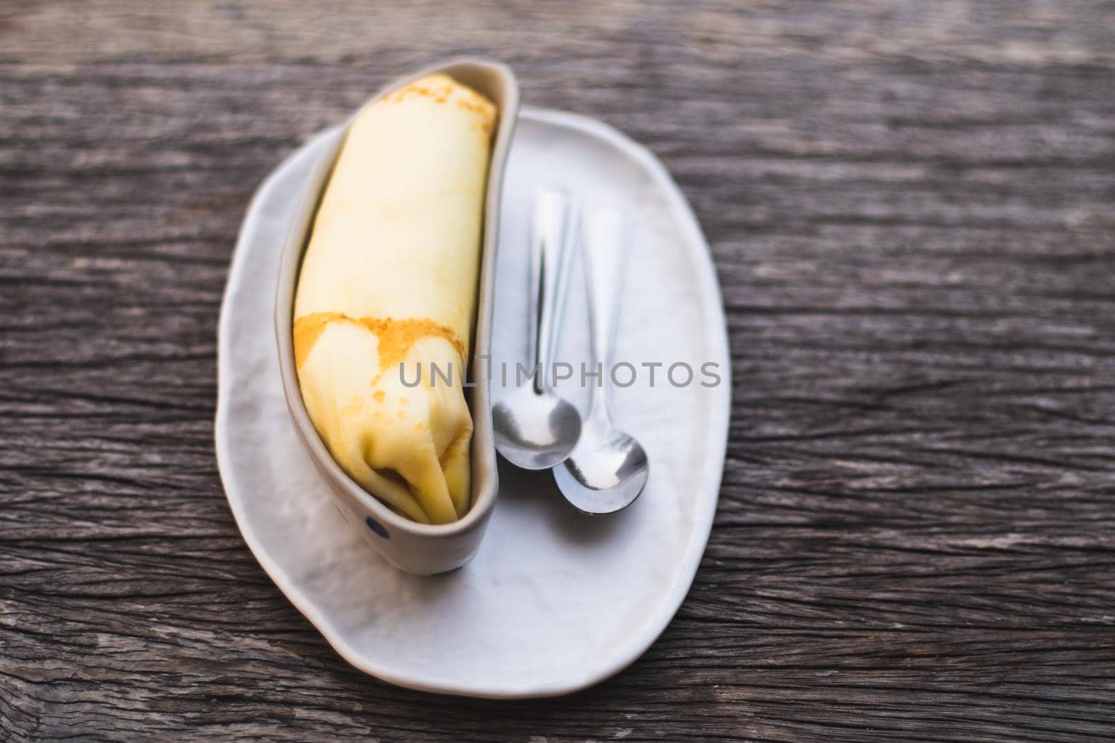Banana crepe sweet dessert object still life. The crepe put in the ceramic container bowl banana shape form design.