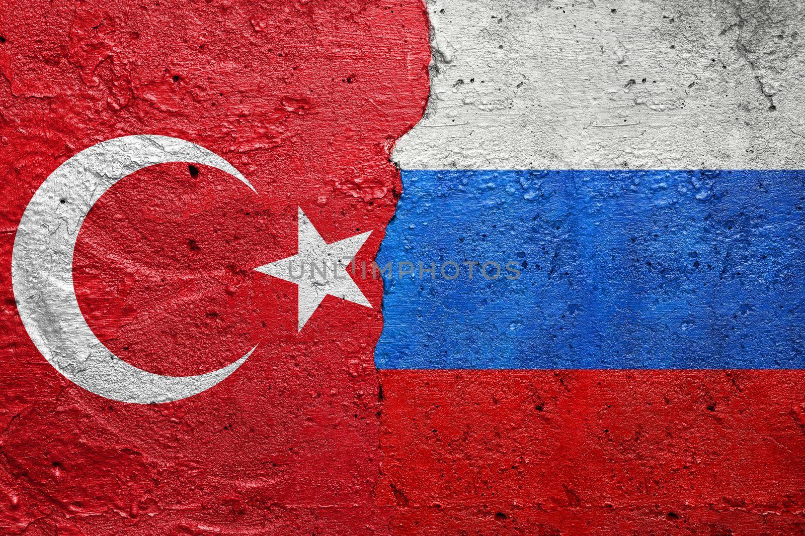 Turkey and Russia - Cracked concrete wall painted with a Turkish flag on the left and a Russian Federation flag on the right stock photo by adamr