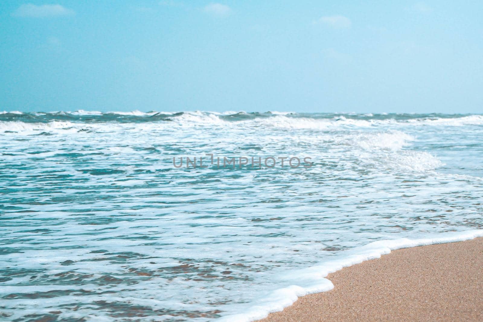 Soft wave with bubble of Blue Ocean on white sand at tropical beach on summer season. Simple beach background for summer. Bubble blue wave from sea to sand on the beach. Summer background.