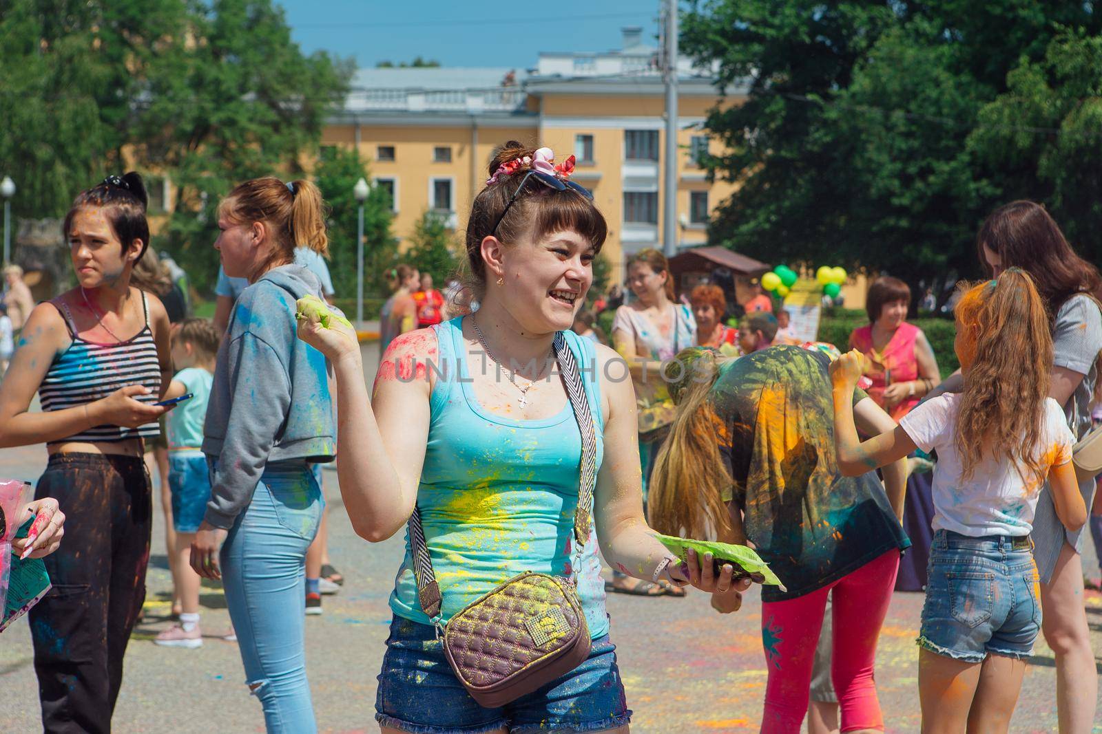 Novokuznetsk, Kemerovo region, Russia - June 12, 2022 :: Woman with colorful face painted with holi powder having fun outdoors.