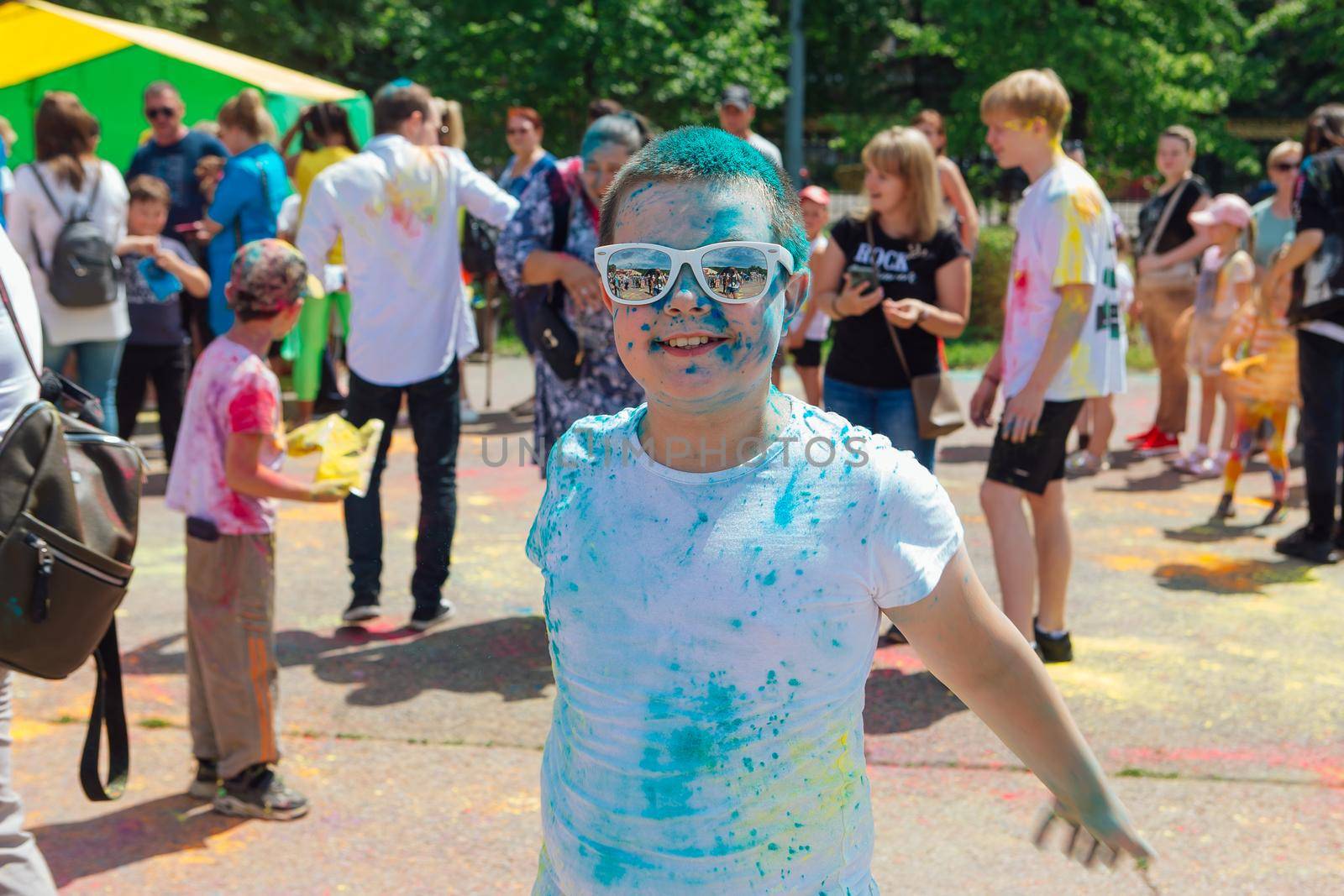 Novokuznetsk, Kemerovo region, Russia - June 12, 2022 :: Boy with colorful face painted with holi powder having fun outdoors.