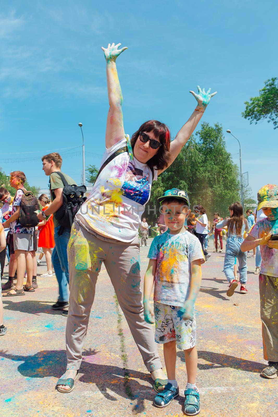 Novokuznetsk, Kemerovo region, Russia - June 12, 2022 :: Mother and son with colorful faces painted with holi powder having fun outdoors.