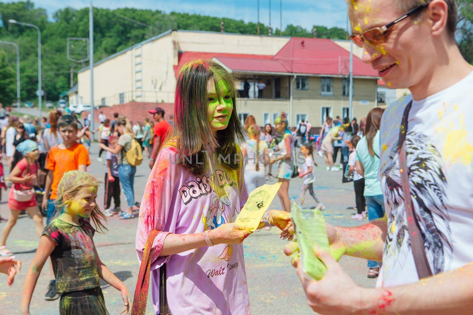 Novokuznetsk, Kemerovo region, Russia - June 12, 2022 :: Teenagers with colorful faces painted with holi powder having fun outdoors.