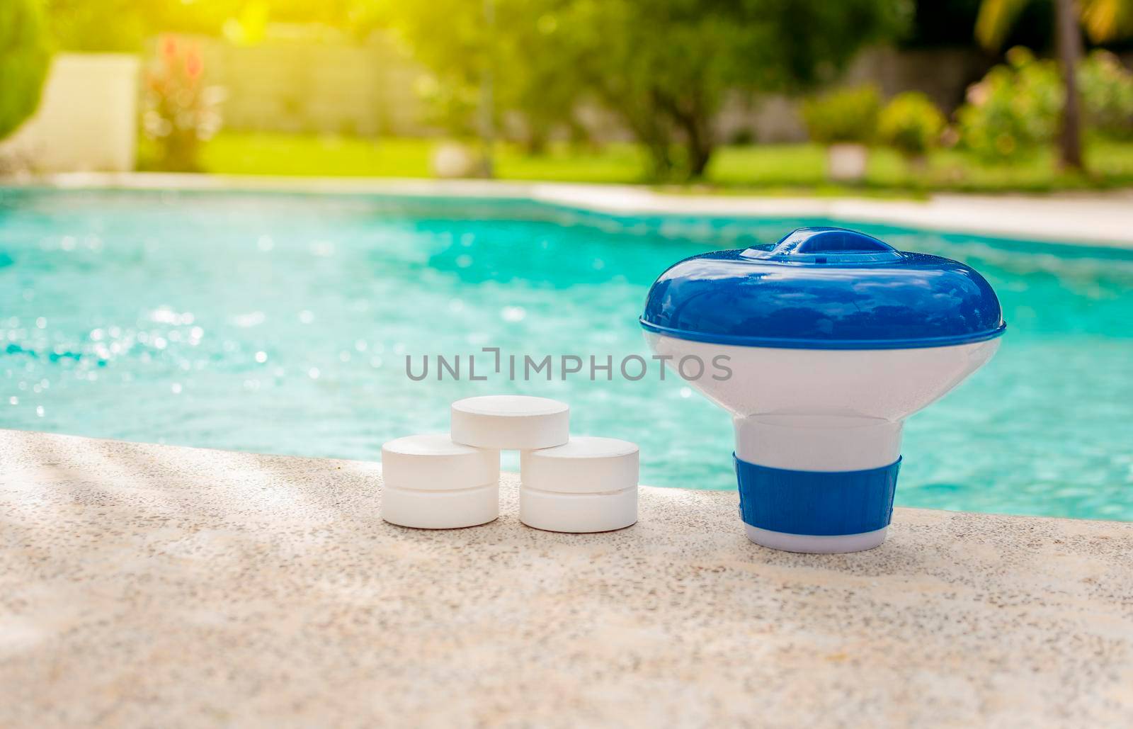 A pool float and chlorine tablets on the edge of a swimming pool. Tablets with chlorine dispenser for swimming pools. Chlorine tablets with dosing float, Pool float and chlorine tablets