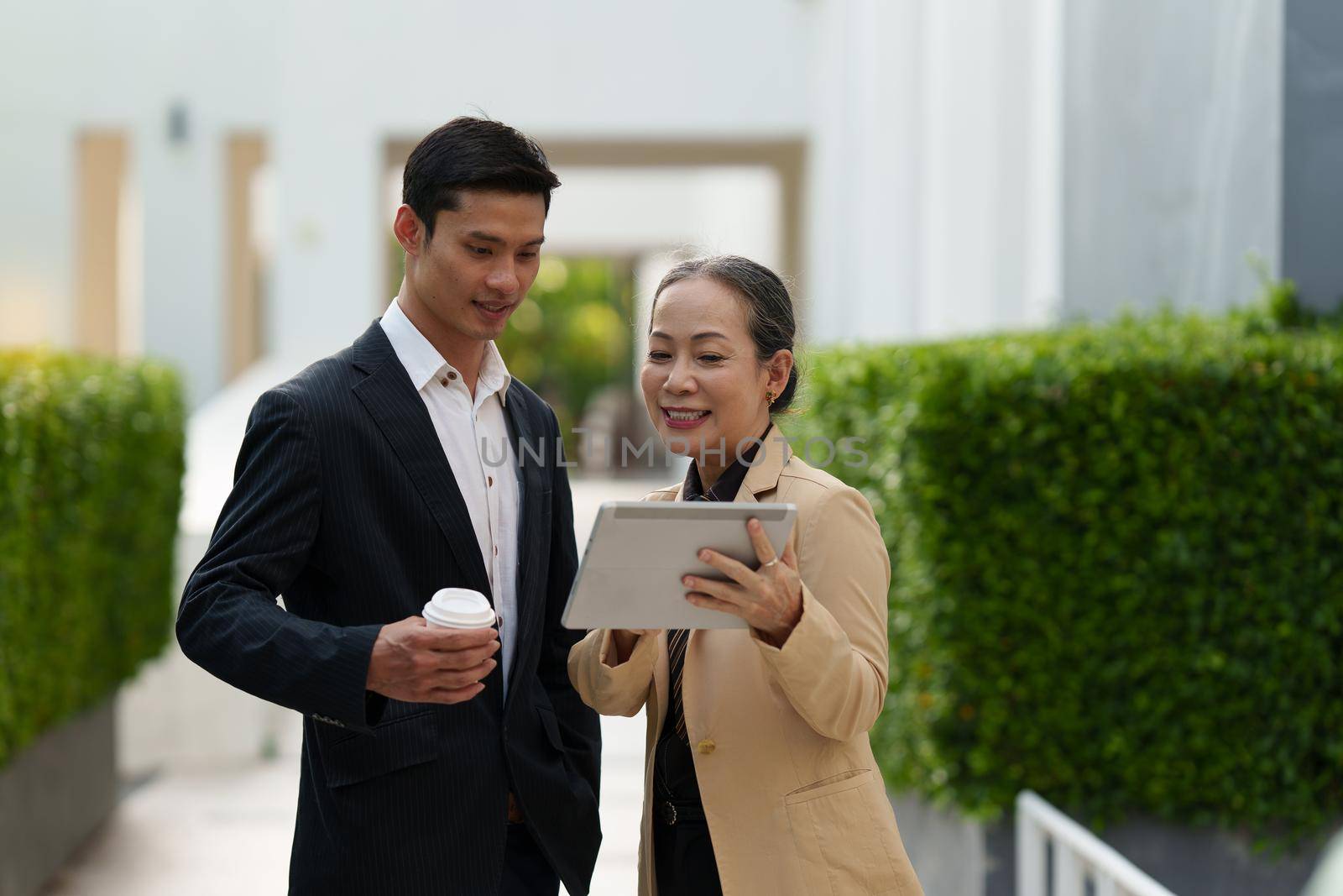 Portrait of Asian Senior Business woman and young business man discussing about Real Estate project