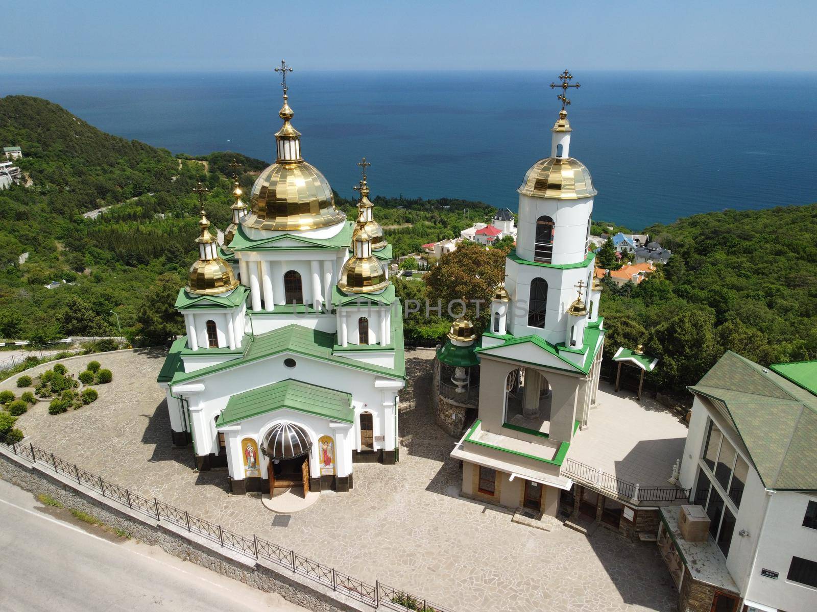 Christian church on a background of mountains. Temple of the Holy Archangel Michael in Oreanda. The southern coast of Crimea. Located on a rocky cliff and is surrounded by beautiful vegetation