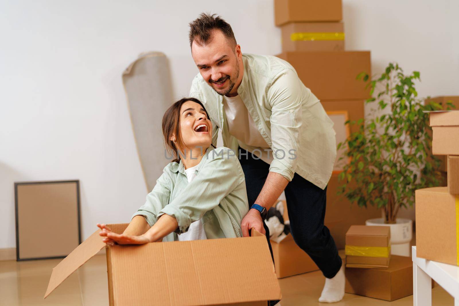 Young happy couple in room with lots of moving boxes at new home