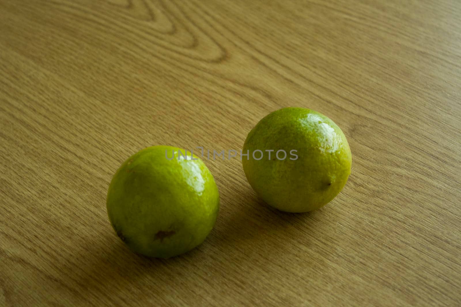 Two limes on a wooden table. Healthy life concept. Food photography.