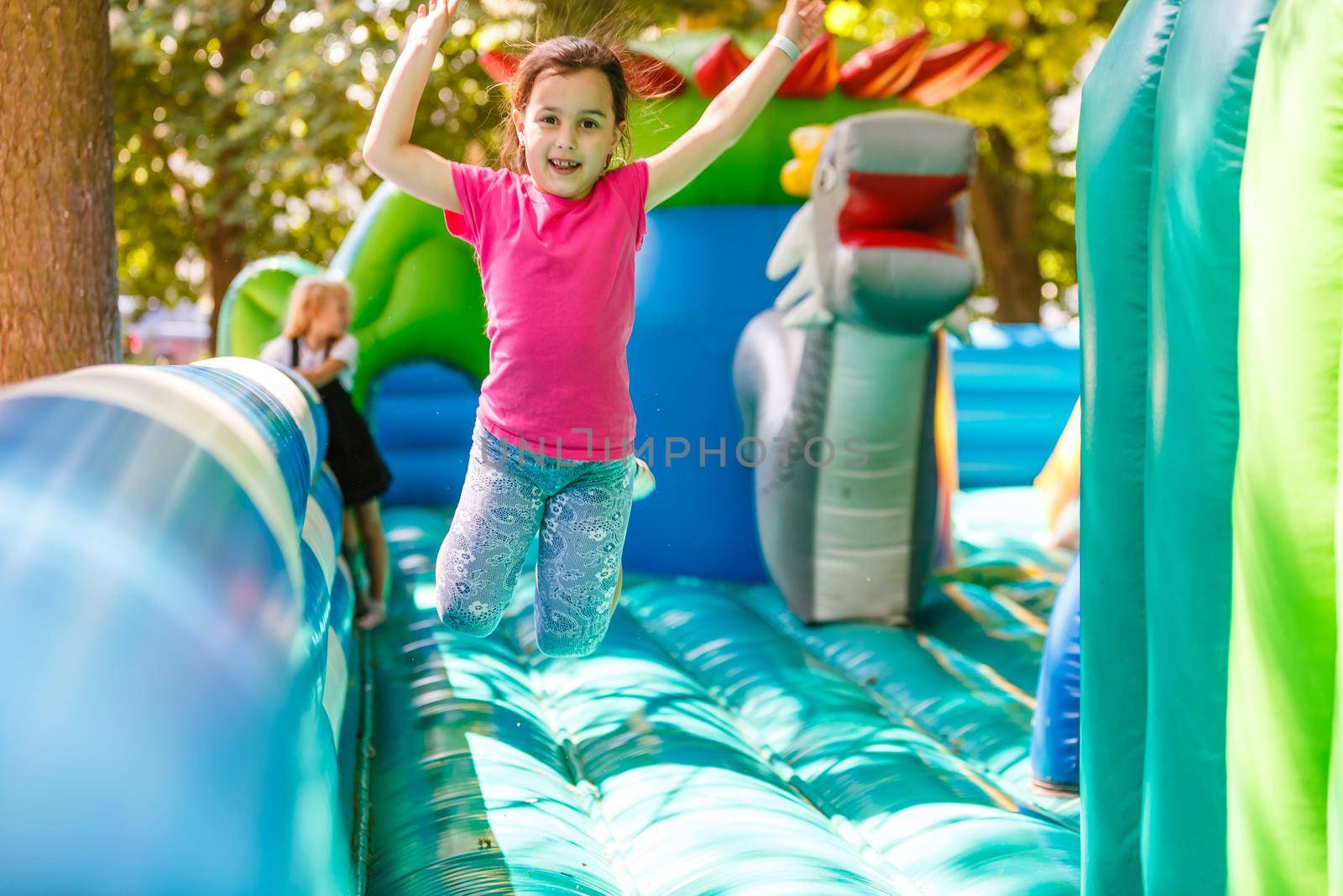 A cheerful child plays in an inflatable castle.