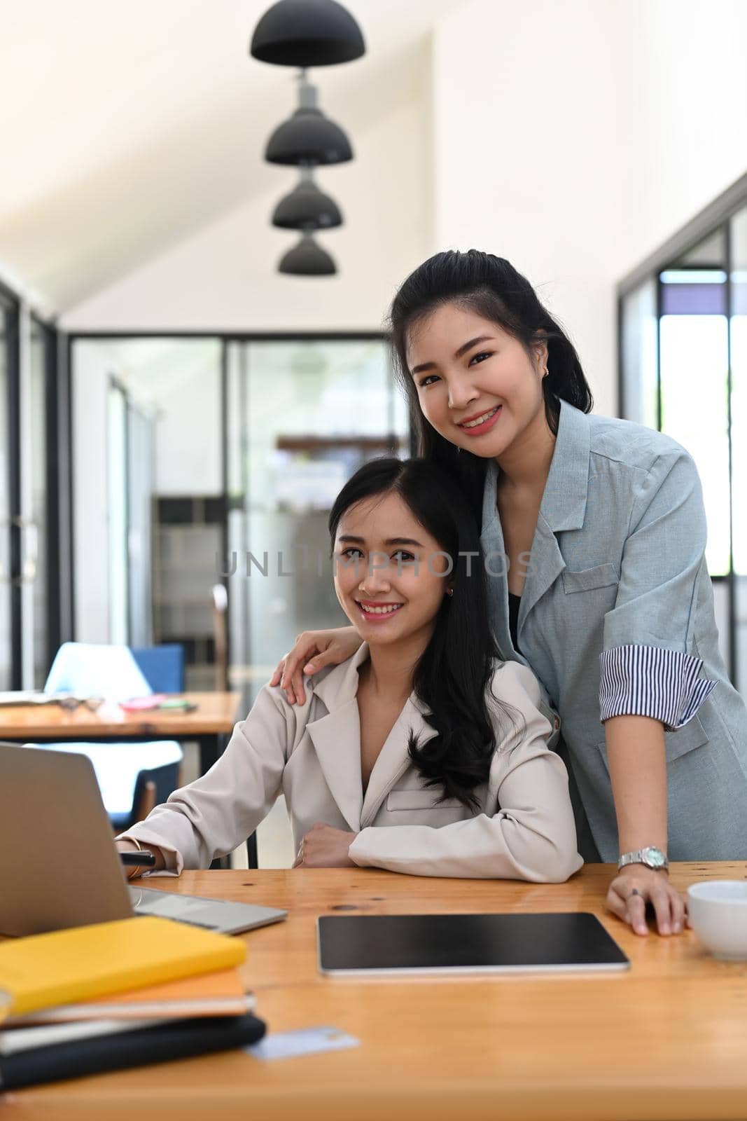 Two successful young businesswoman working in modern workplace. by prathanchorruangsak