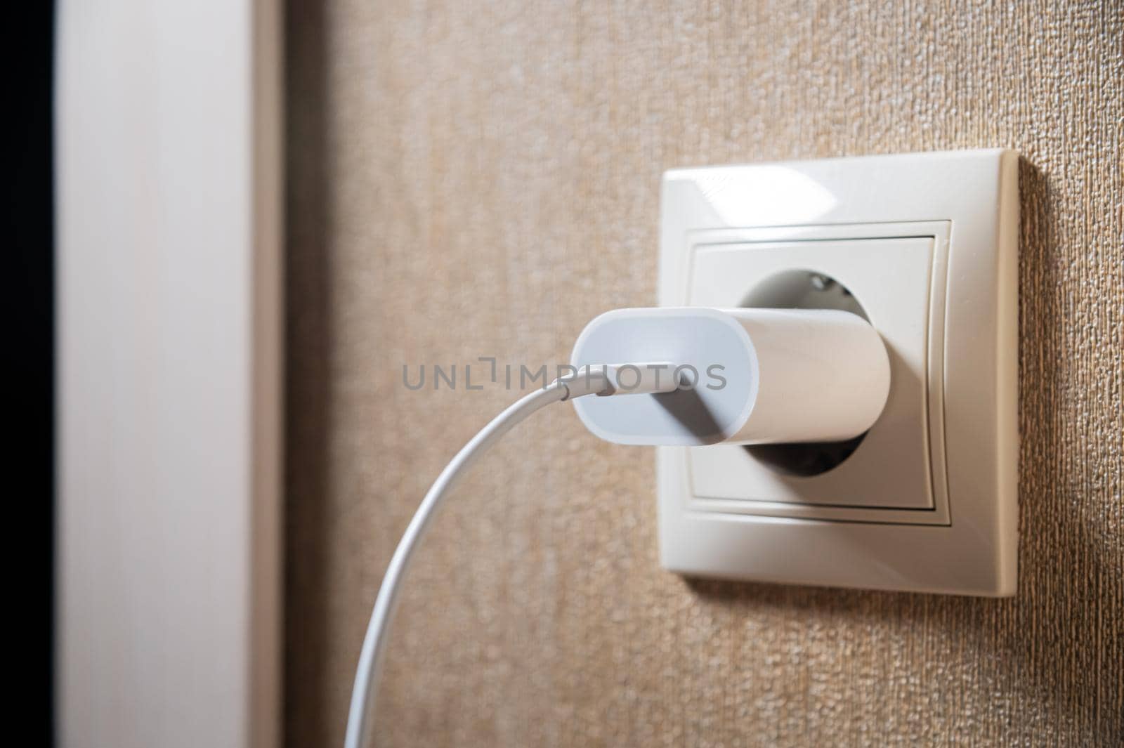 Close-up of a usb charging unit with a usb c connector and a white wire. European socket. The concept of providing electricity to the European Union.