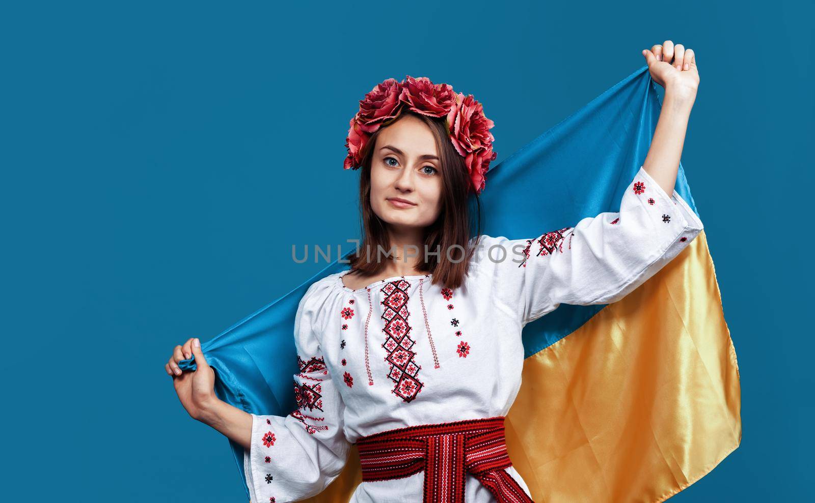 Ukraine patriotic concept. Beautiful girl in the Ukrainian national suit with Ukrainian flag