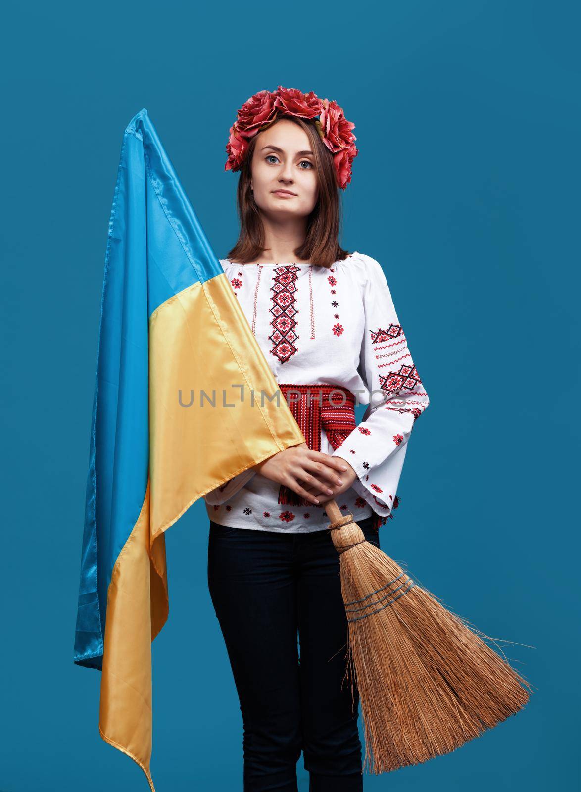 Ukraine patriotic concept. Beautiful girl in the Ukrainian national suit with Ukrainian flag