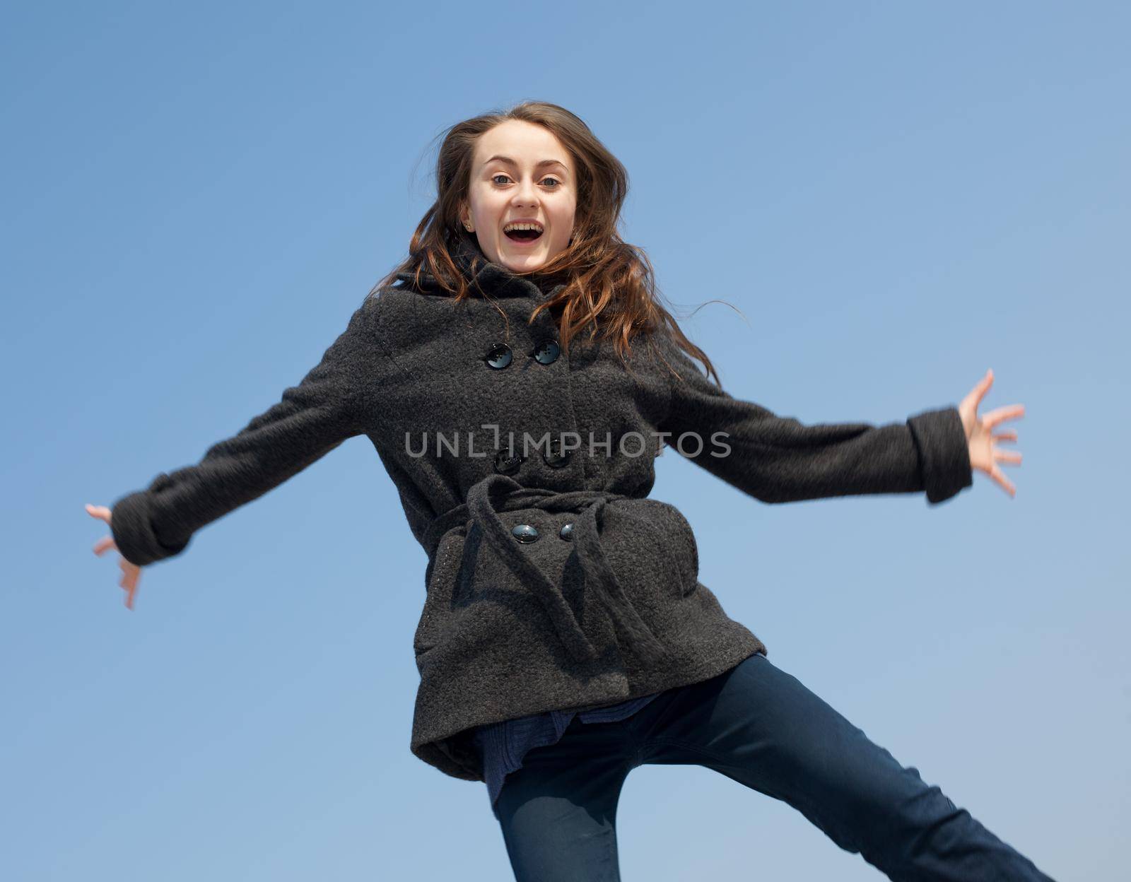 Joyful young woman against blue sky  background