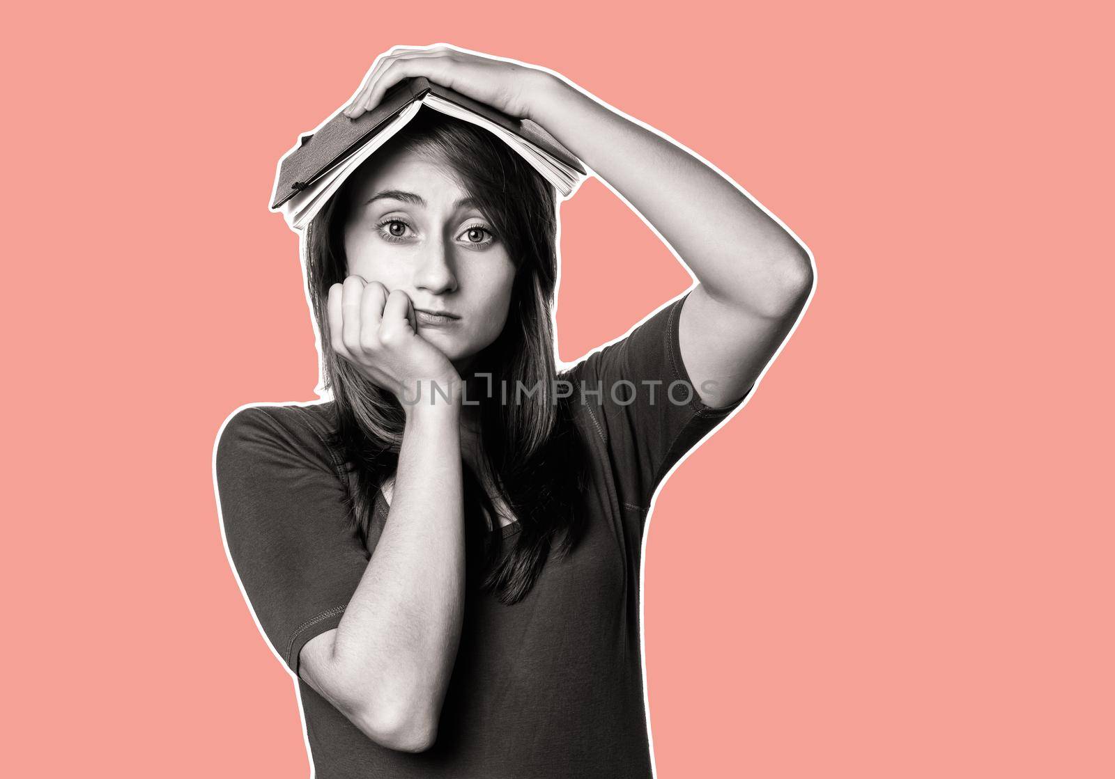 Education and lifestyle concept. Tired girl holds a notebook on her head.  Magazine style collage with copy space and trendy coral color background