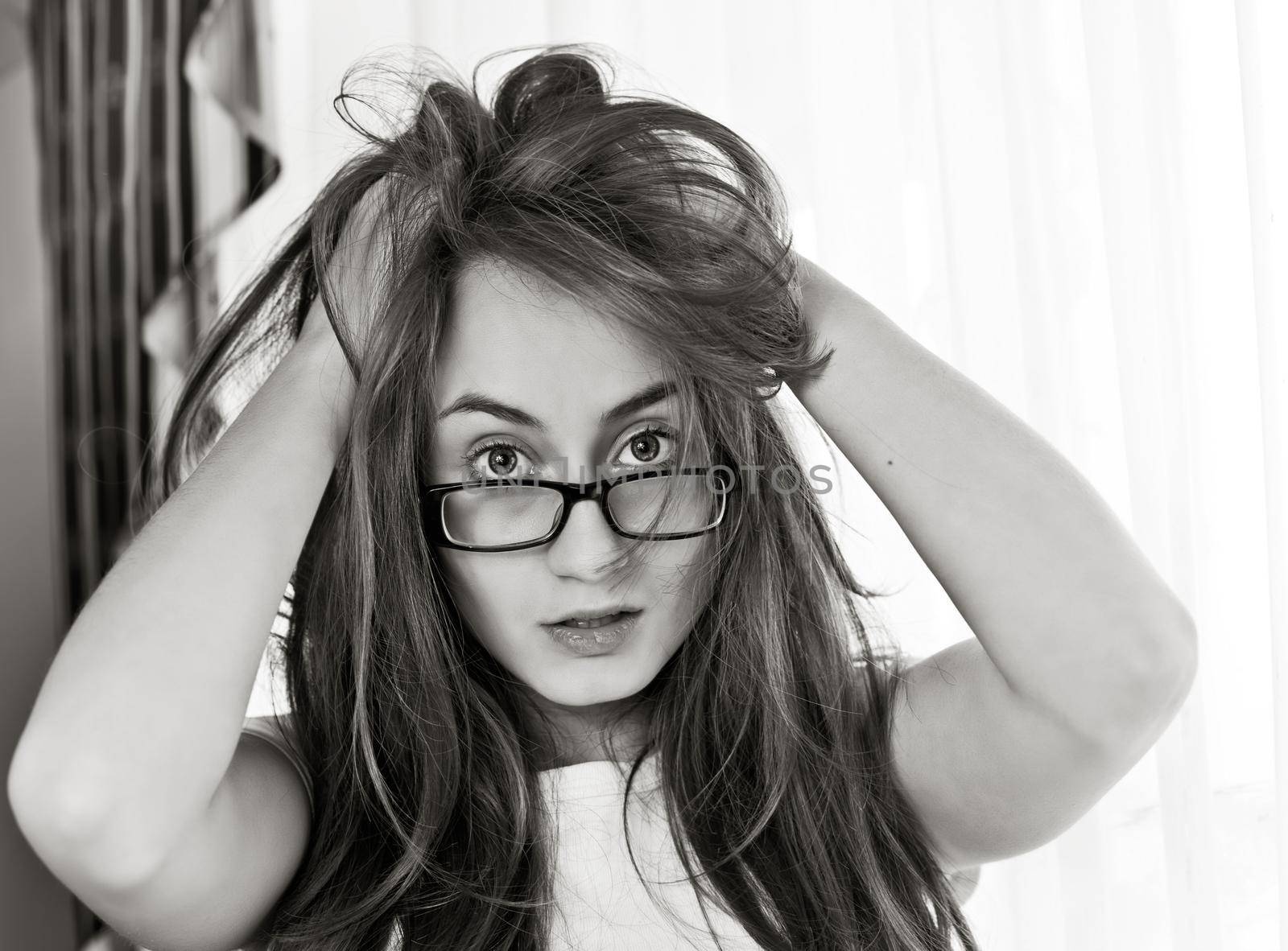 Young woman with disheveled hair in glasses