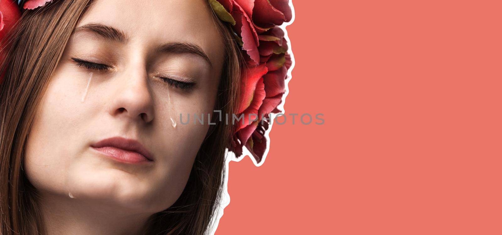 Close-up portrait of beautiful crying girl with tears. Magazine style collage with copy space and trendy coral color background