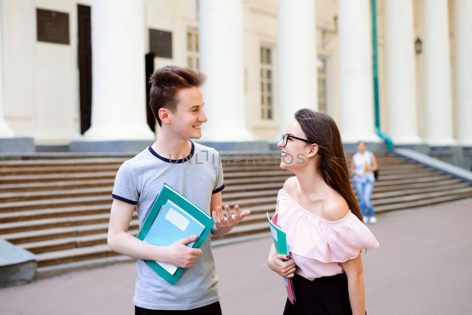 Students walking and having a talk near university by VitaliiPetrushenko