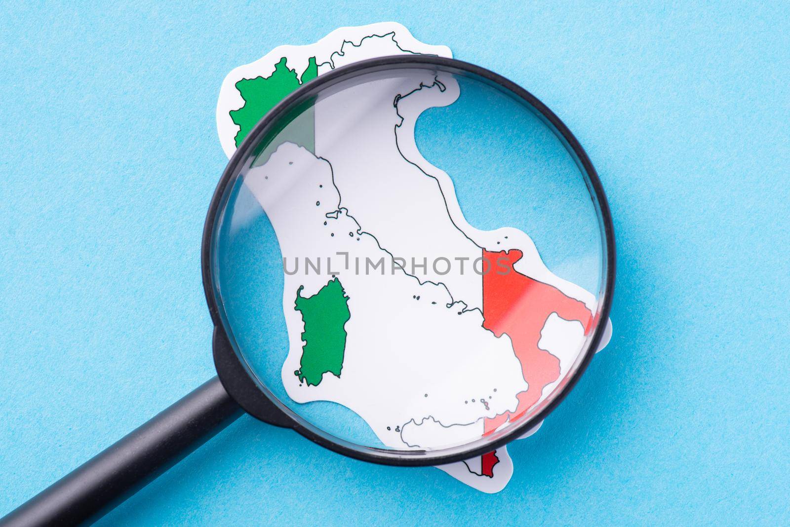 Magnifying glass on map and flag of Italy