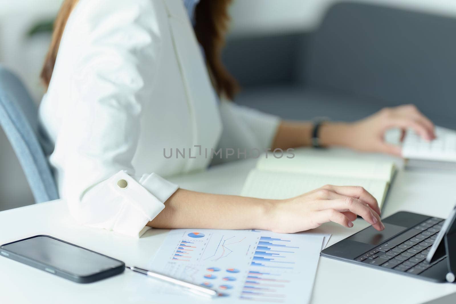 Asian businesswoman or business owner using Tablet computer and calculator.