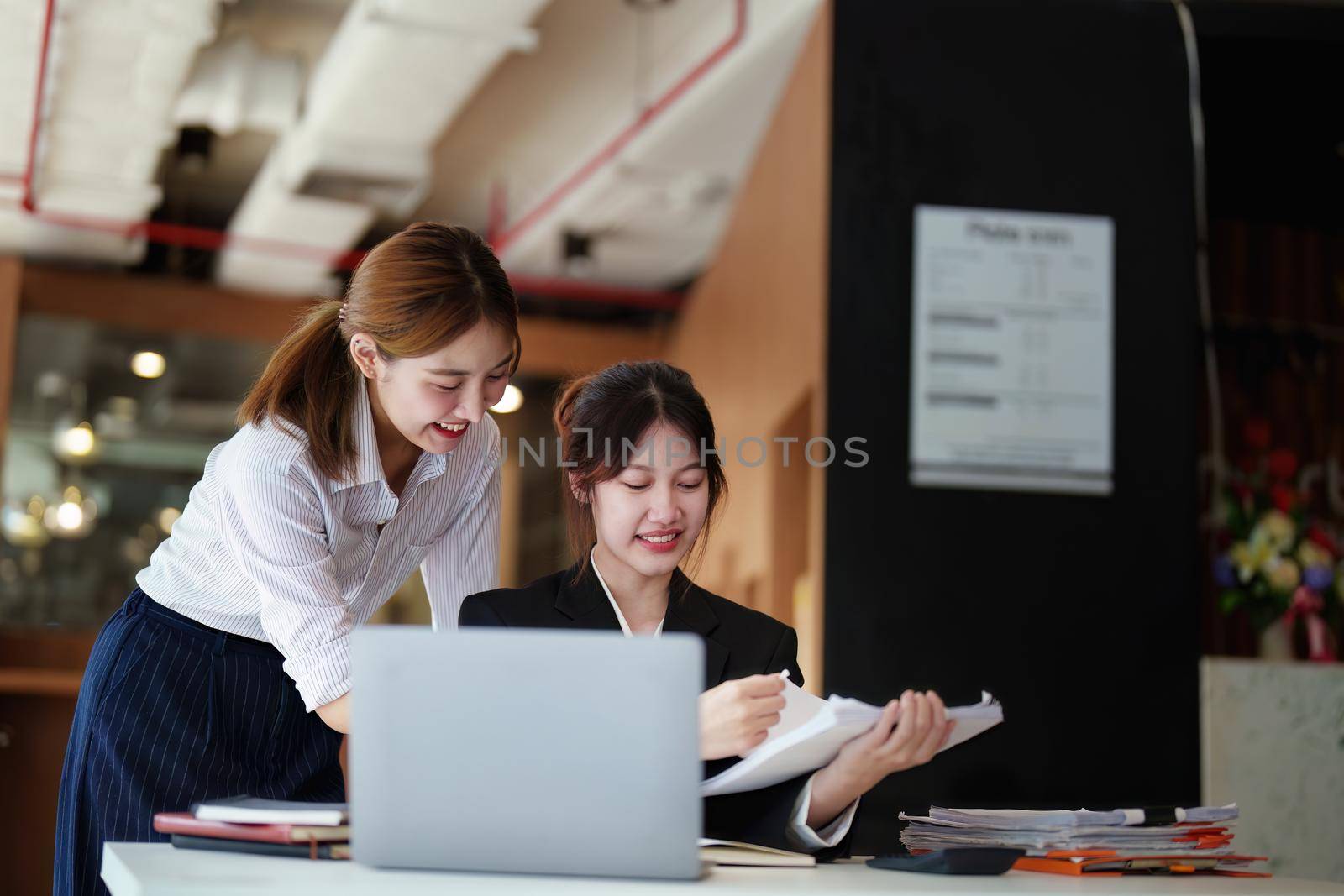 A portrait of two young Asian businesswoman plan marketing strategies and investments to profit from their clients by Manastrong