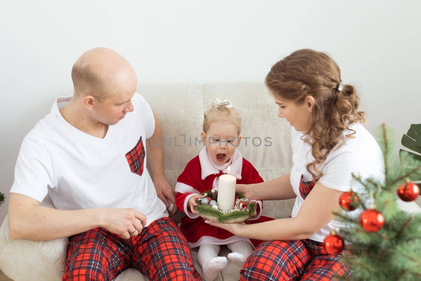 Child with cochlear implant hearing aid having fun with parents in christmas living room - diversity , deafness treatment and medical innovative technologies by Satura86