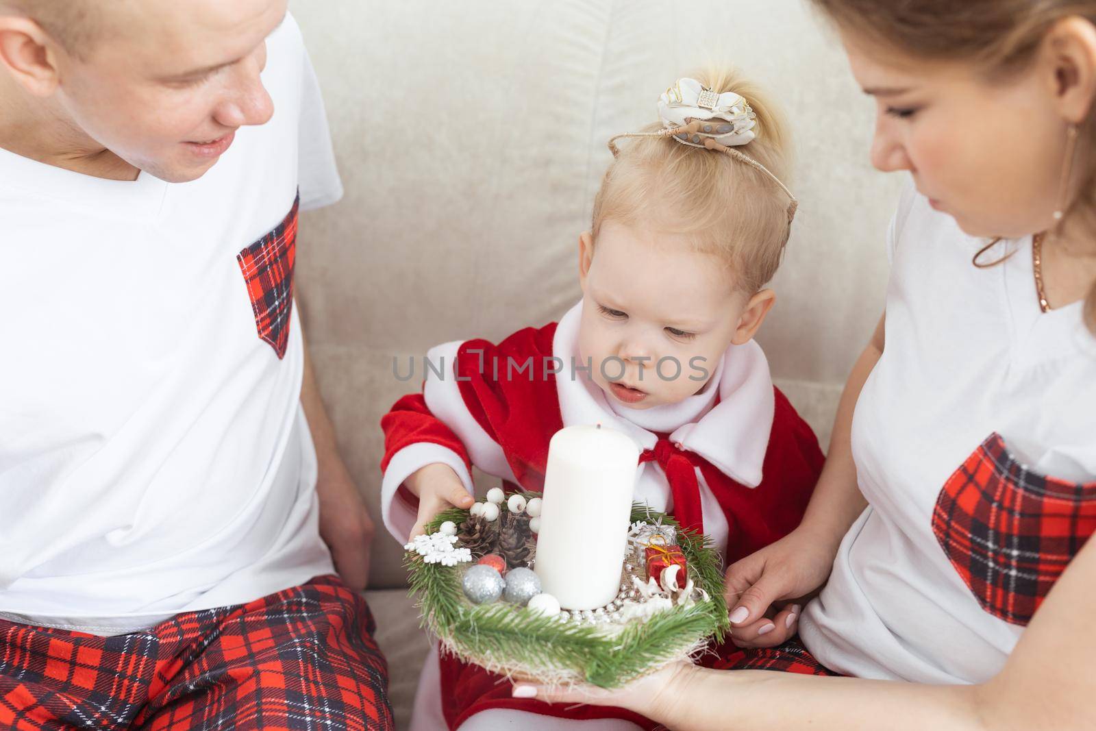 Baby child with hearing aid and cochlear implant having fun with parents in christmas room. Deaf and health