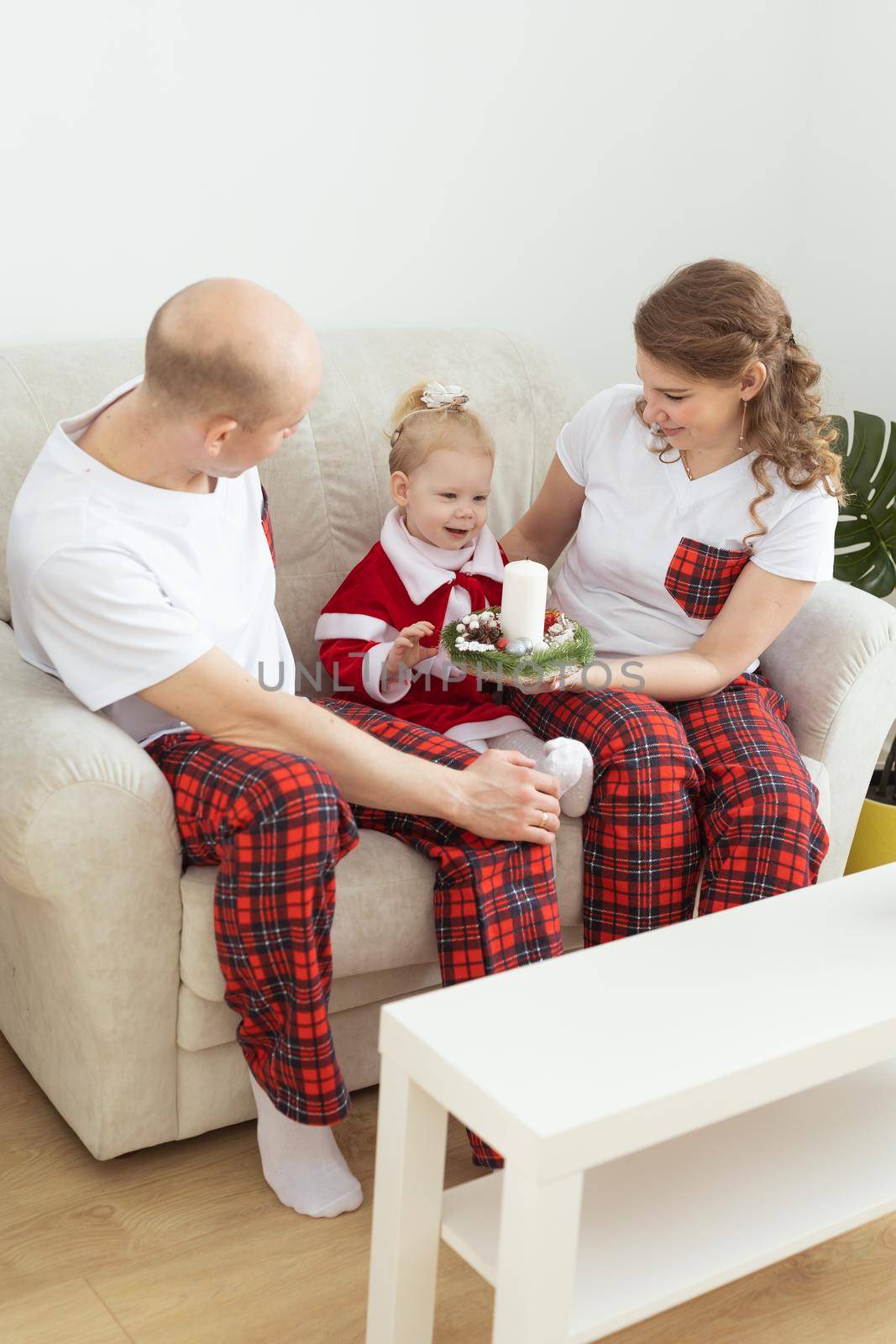 Child with cochlear implant hearing aid having fun with parents in christmas living room - diversity , deafness treatment and medical innovative technologies by Satura86