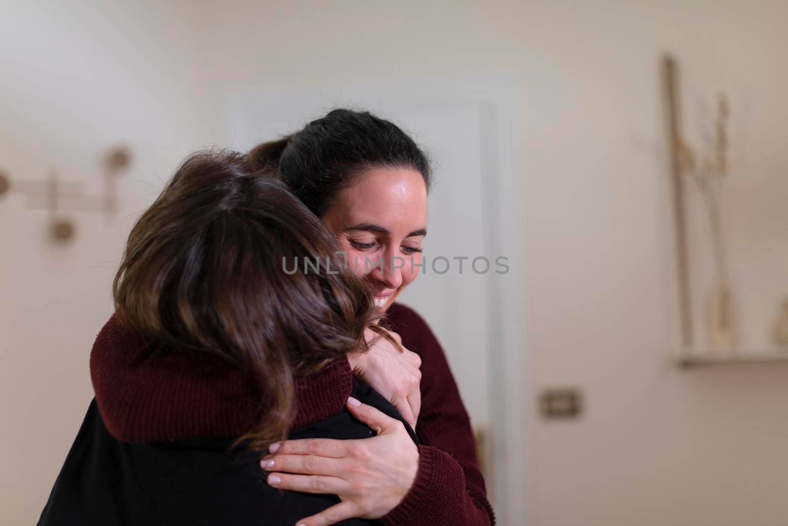 A female patient hugs with joy and warmth her friend therapist for resolving her health issues